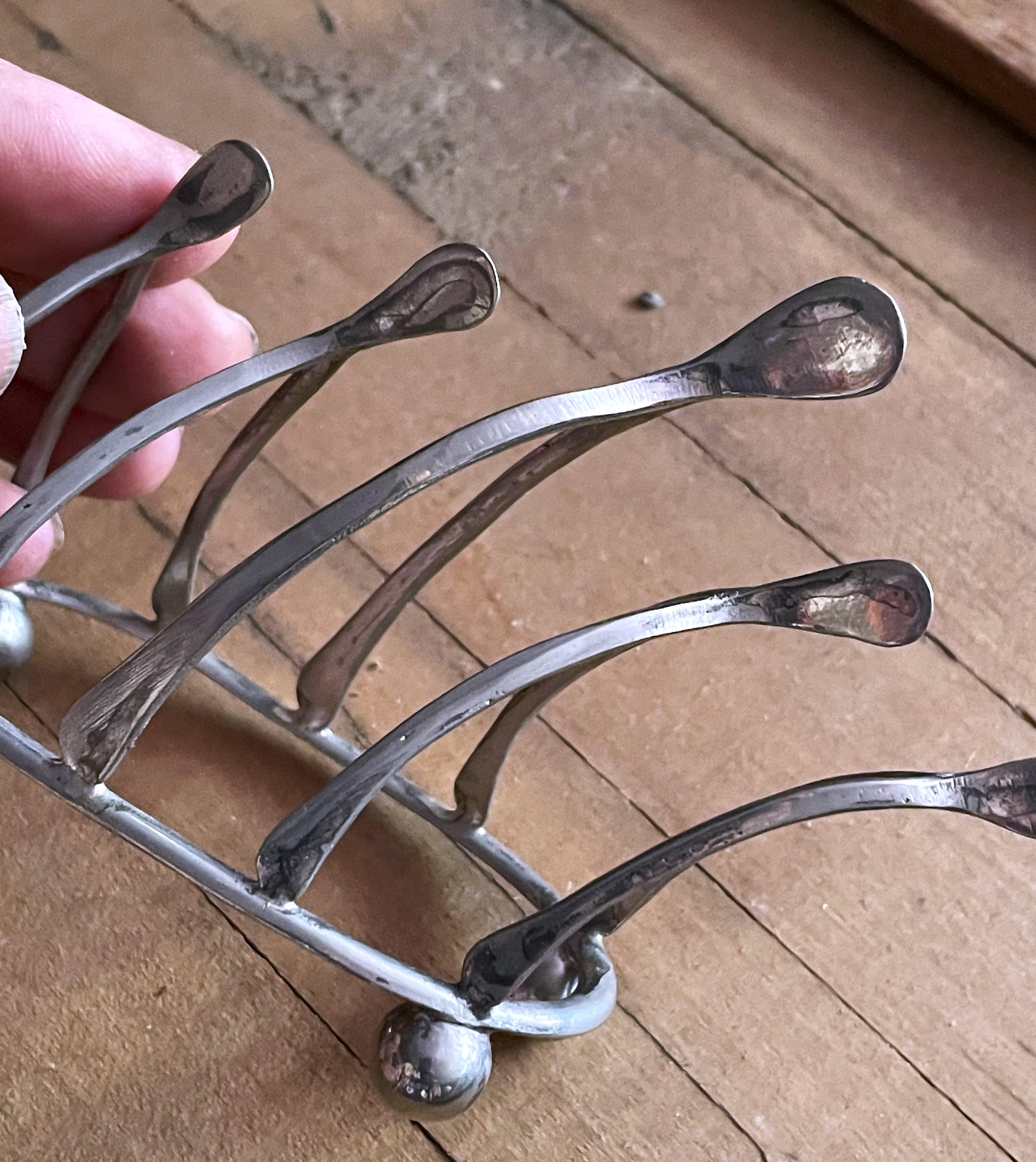 This is the cutest way to serve toast (or keep correspondence sorted). It has five wishbone shaped dividers, the center one being the largest, and sweet ball feet on the bottom. I could not find a mark but I can see where the silver plate has worn