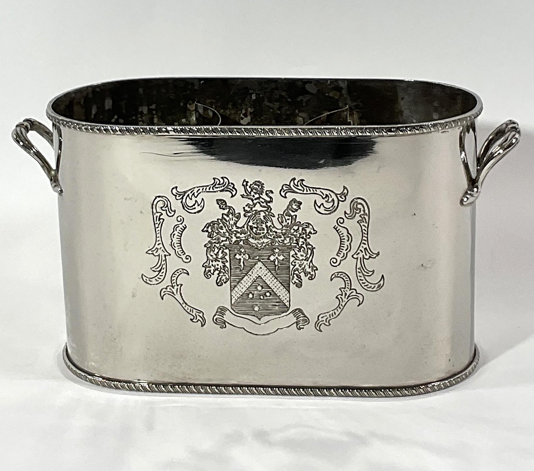 Wine cooler with engraved coats of arms with lion and shield. Two spaces for bottles and ice bin in center. Classis piece of barware. English. Circa 1940.