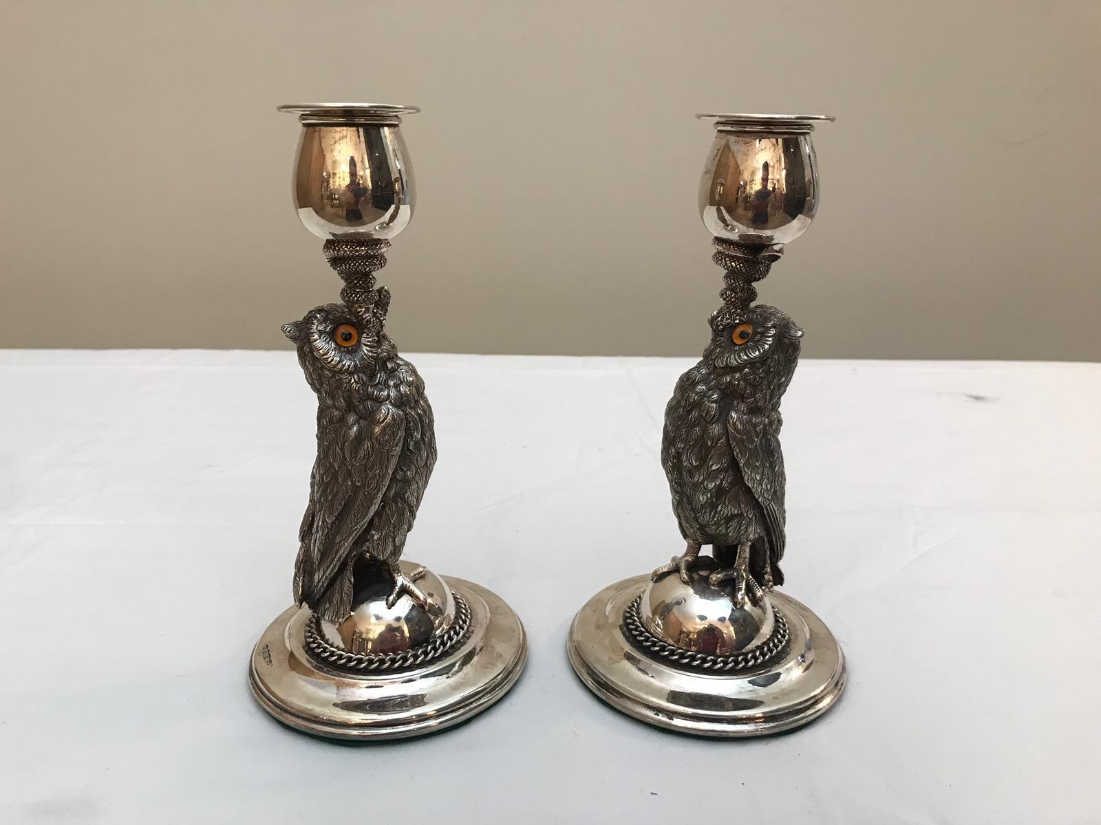 A pair of candlesticks by Roberts and Belk in the form of an owl with a snake. The owls have glass eyes.
