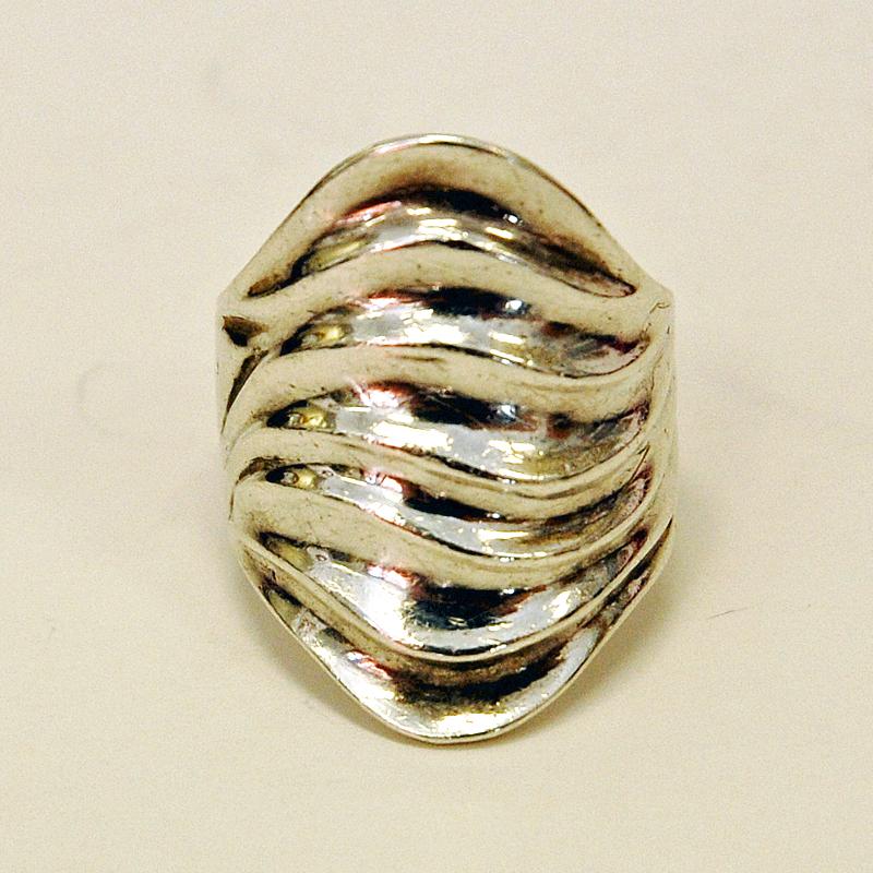 Special vintage silver ring with a bigger surface divided into several layers like waves on water. Made by Andersen Gravyr & Guldsmedsverk 1970s. Classic and simple vintage ring. Looks very good on. 
Marked GHA and 925 silvermark. Inner diameter is