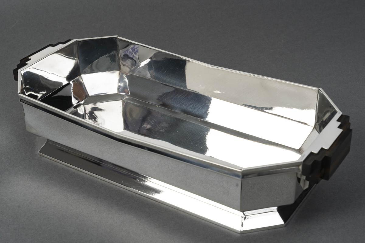 Silver planter in octagonal shape with a V-shaped side cutout, mounted on a pedestal base,

this object is flanked by two wooden handles decorated with steps, riveted to the planter itself.

Masterwork designed by Valéry BIZUARD (1875-1945),