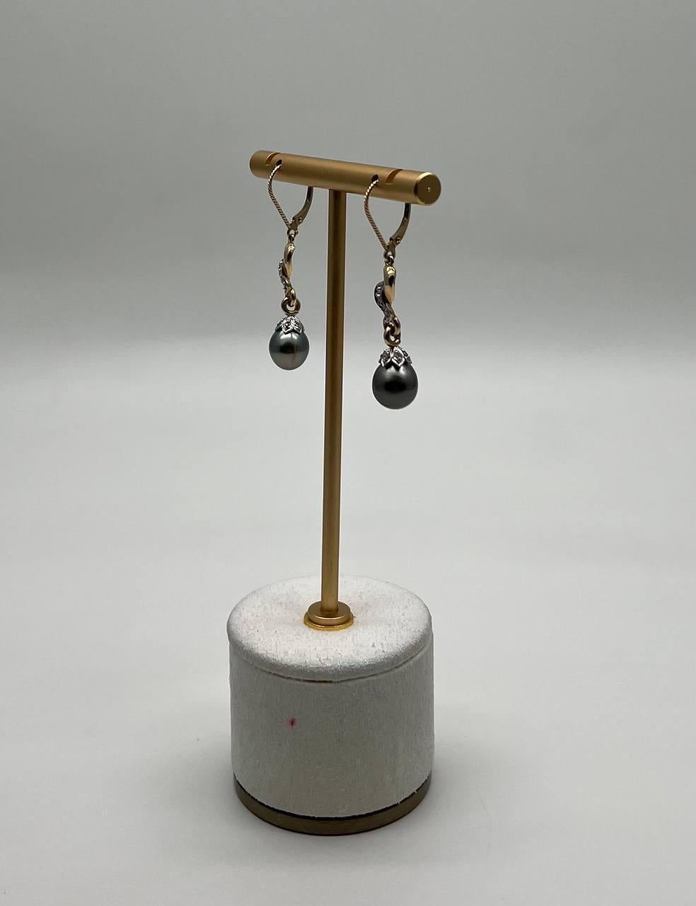 Elegant and contemporary, these exquisite drop earrings feature lustrous dark pearls suspended from a delicate twist of shimmering accents.
Sophisticated and timeless adornments. 14K Yellow Gold. Natural Pearls. 0.10 CTW Diamonds.