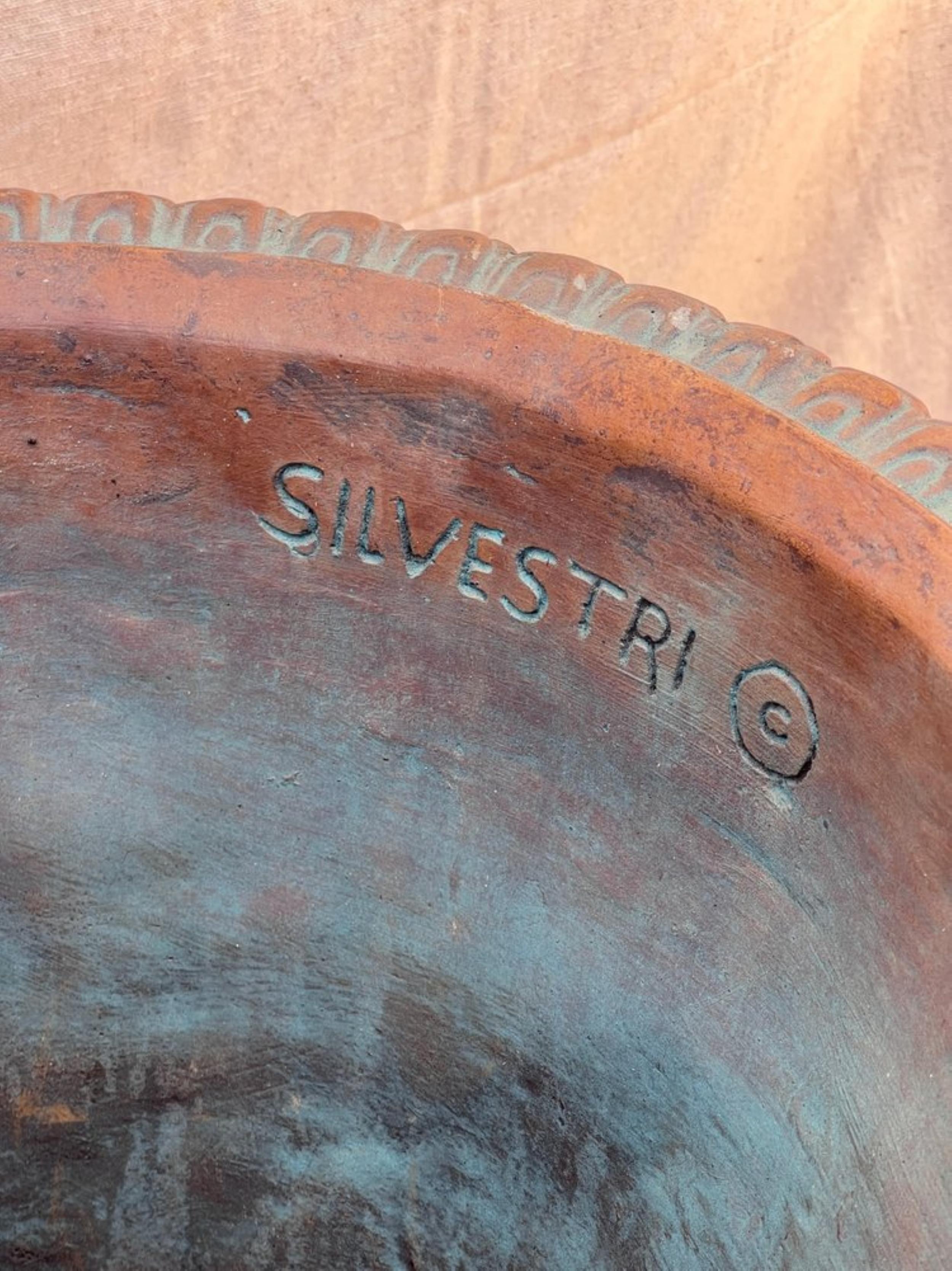 Elevate your outdoor living with the Silvestri terracotta ornate planter. This exquisite piece, reminiscent of a classic urn, combines the rustic charm of terracotta with delicate hints of blue patina, creating a masterpiece that transcends eras.