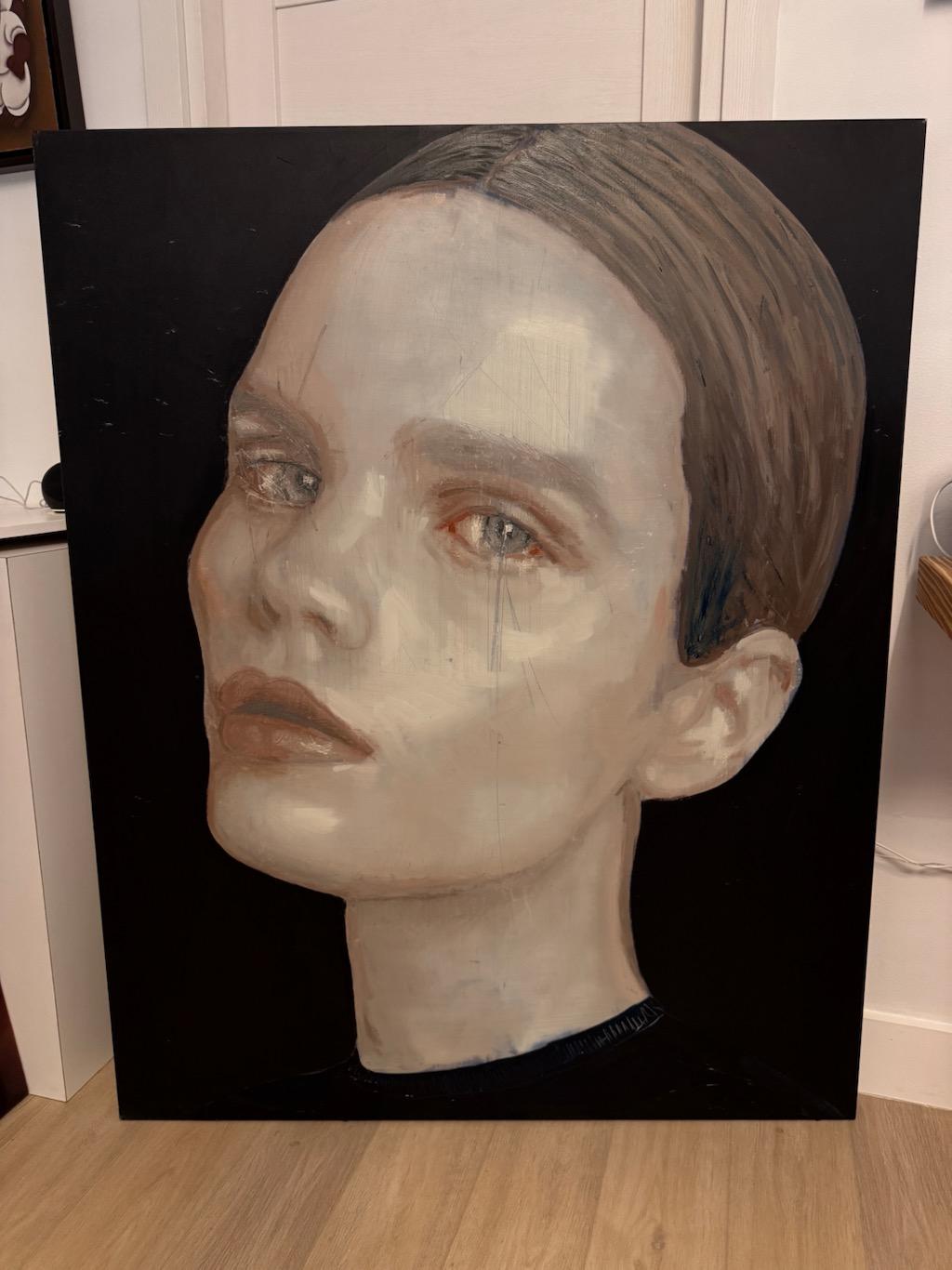Teens Blue is a captivating original painting by contemporary artist Silvia Berton, known for her emotive and expressive portraits. This striking piece features a close-up of a young woman’s face with a haunting yet delicate expression. The artist
