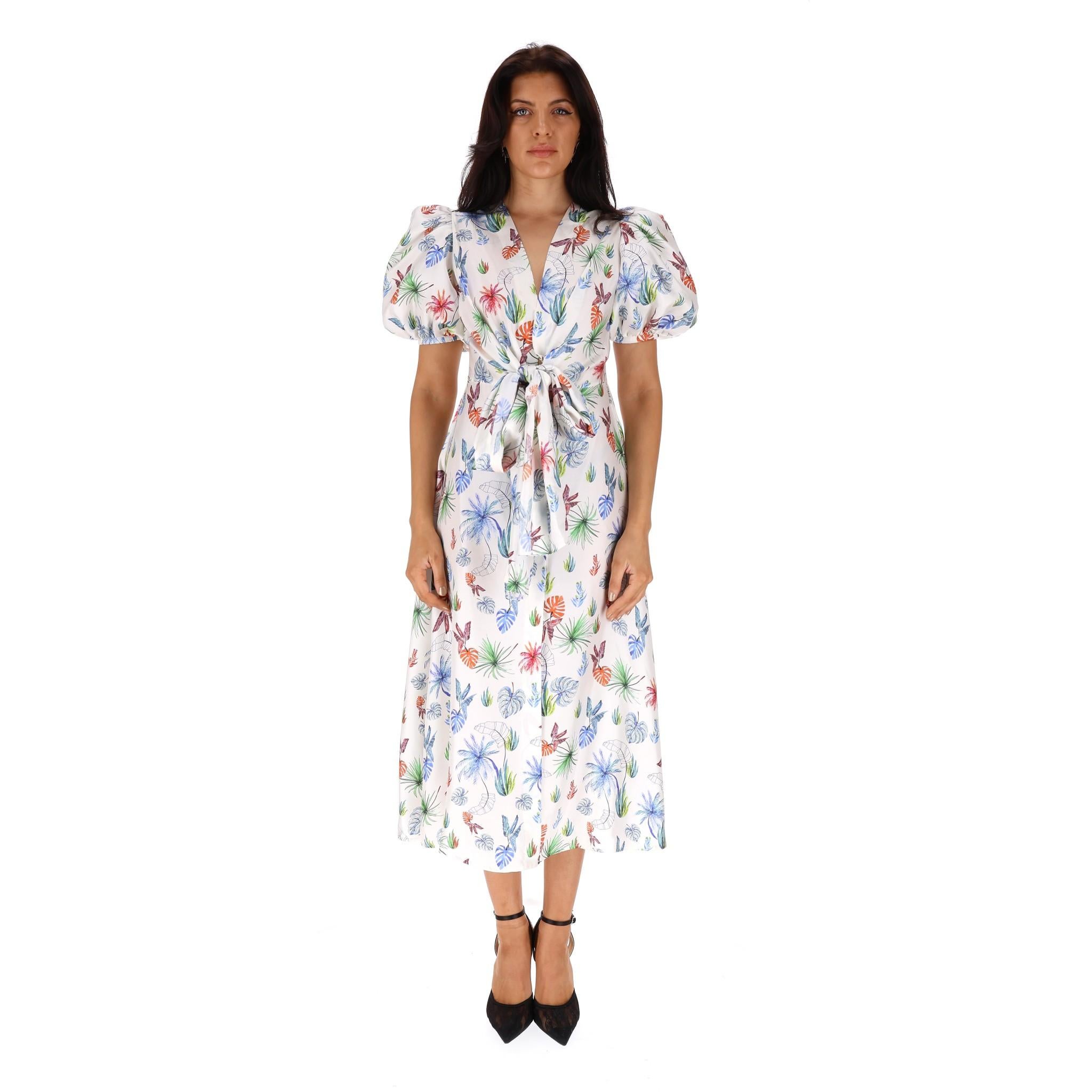 Silvia Tcherassi Printed Silk Dress

White 'Lirio' midi dress designed with multicoloured palm leaf prints.

Detailed with bow tie accent and hidden button closure to the front.

Featuring puffed shoulders, side slit pockets and A-Line silhouette.