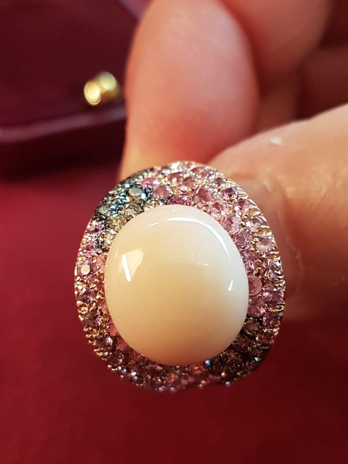 A beautiful, stylish and elegant Rose Gold ring, accented with pink Sapphires (2,07ct) and brown diamonds (0,55ct) that surround a light pink coral stone (1,80gr) bringing into life surprising and amazing color effects.

SILVIO ANCORA designs and