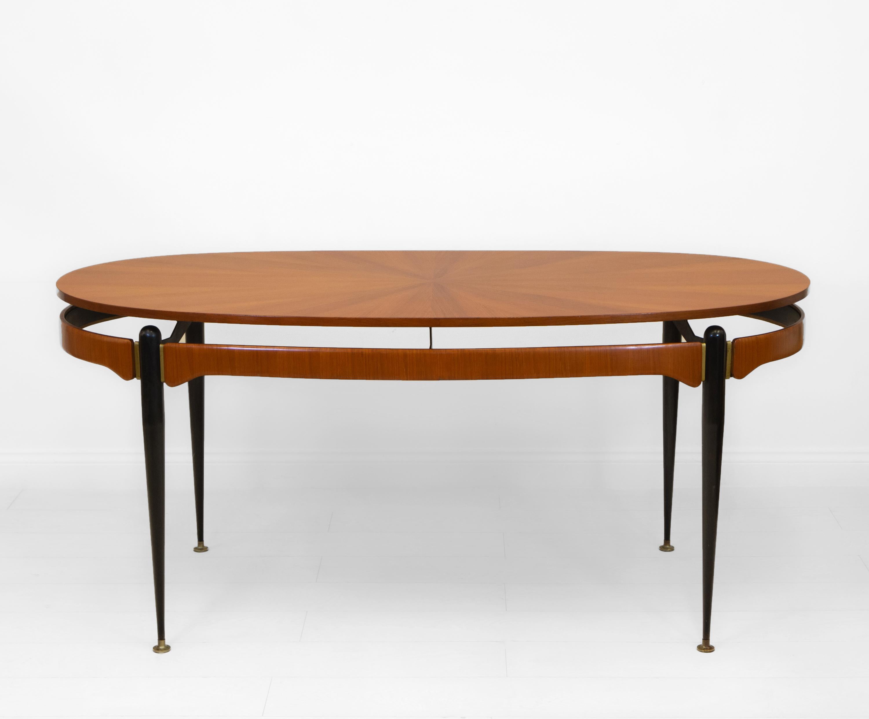 An elegant mid-century Italian oval dining table, attributed to Silvio Cavatorta. Circa 1950.

The fabulous sunburst teak veneer top is a nice, well made example. The clever 'floating' top hovers above an open teak rounded form frieze, giving a