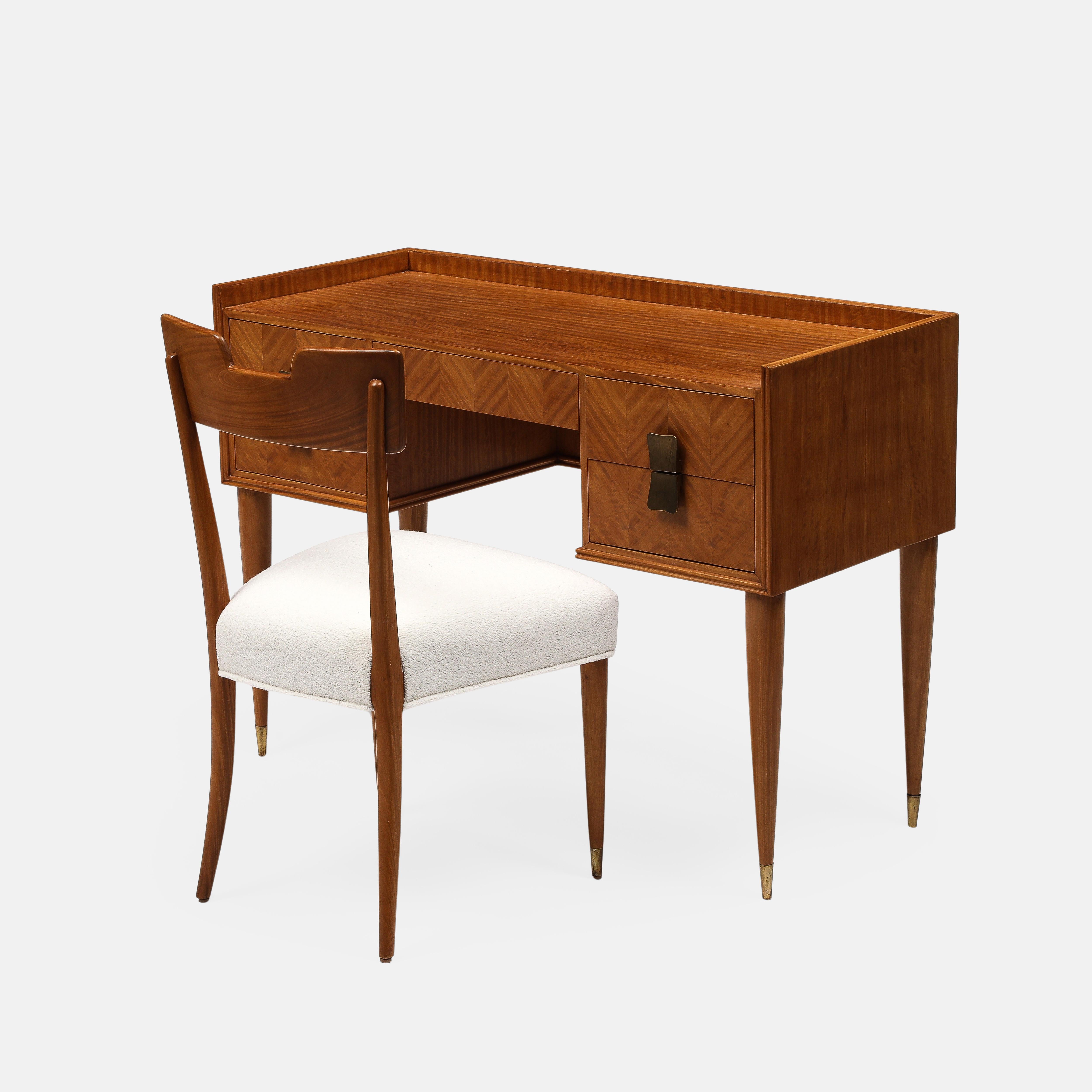 Silvio Cavatorta rare exquisite birch five-drawer desk with brass pulls and ending in brass sabots with matching birch chair with ivory boucle seat and ending in front brass sabots and with back legs slightly kicking out. This elegant stylish desk