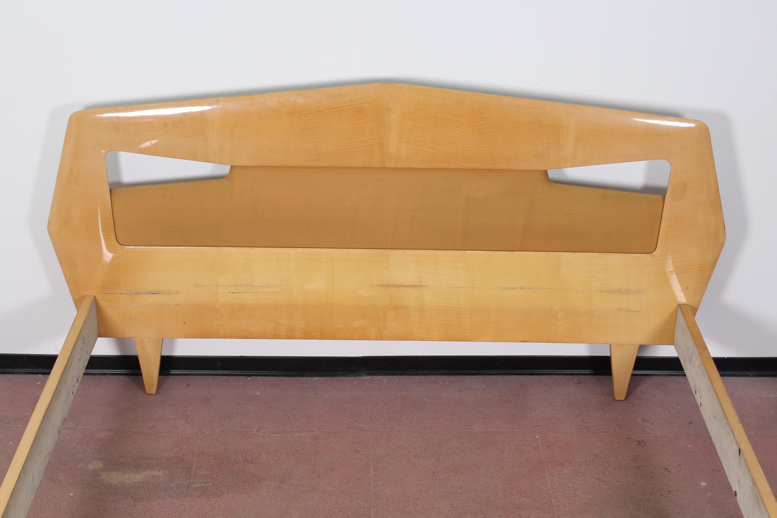 Elegant double bed frame attributed to Silvio Cavatorta and produced by Dassi Lissone in the 1950s. This bed is characterized by a catchy sculptural design.
Its made of a maple wood, with slight signs of wear consistent with age and use.
 