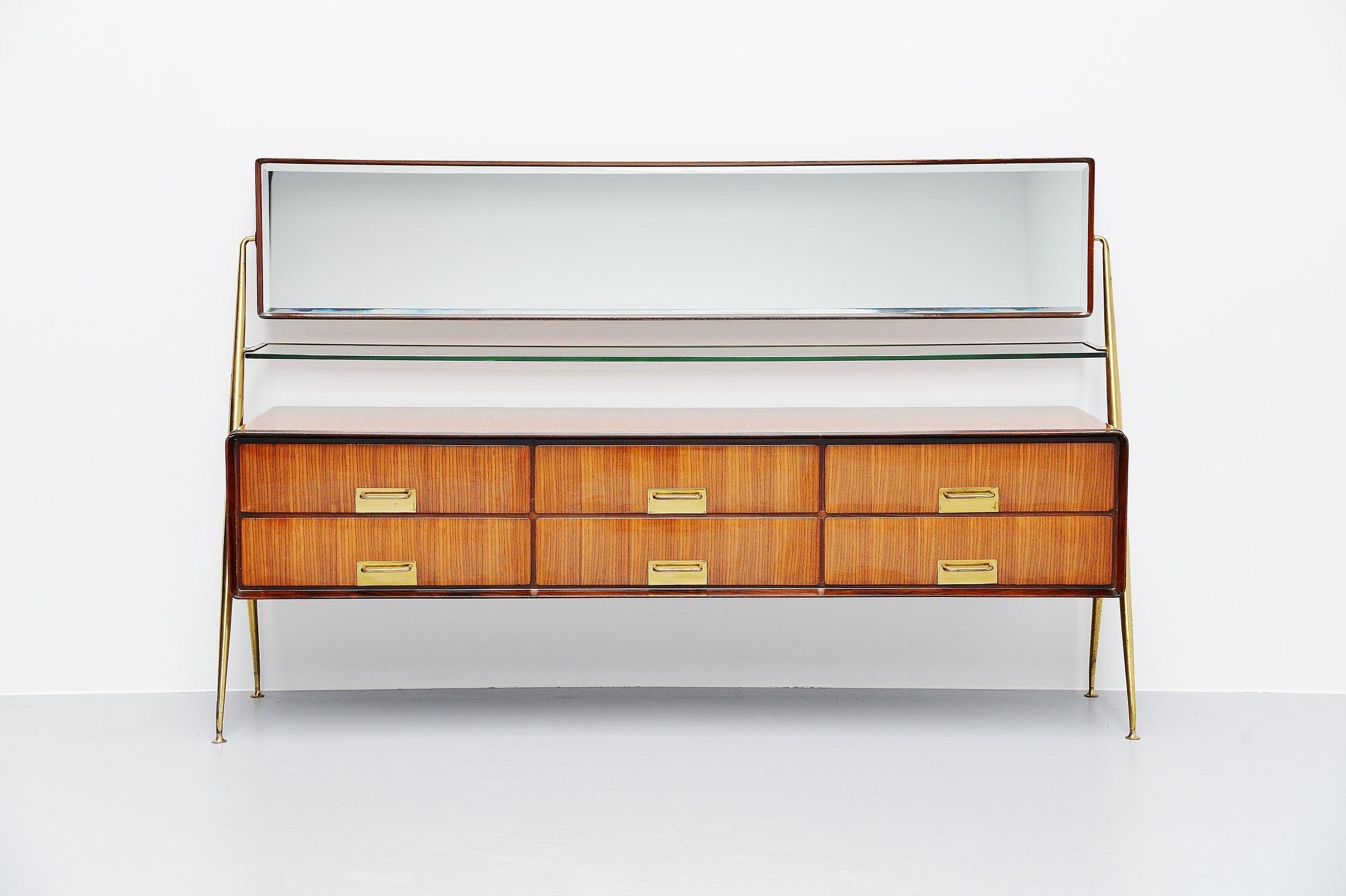 Stunning mirror sideboard designed and manufactured by Silvio Cavatorta, Italy, 1958. This highly refined sideboard has a brass structure, the cabinet is made of high gloss lacquered teak with nice grain to the wood and the 6 drawers have brass