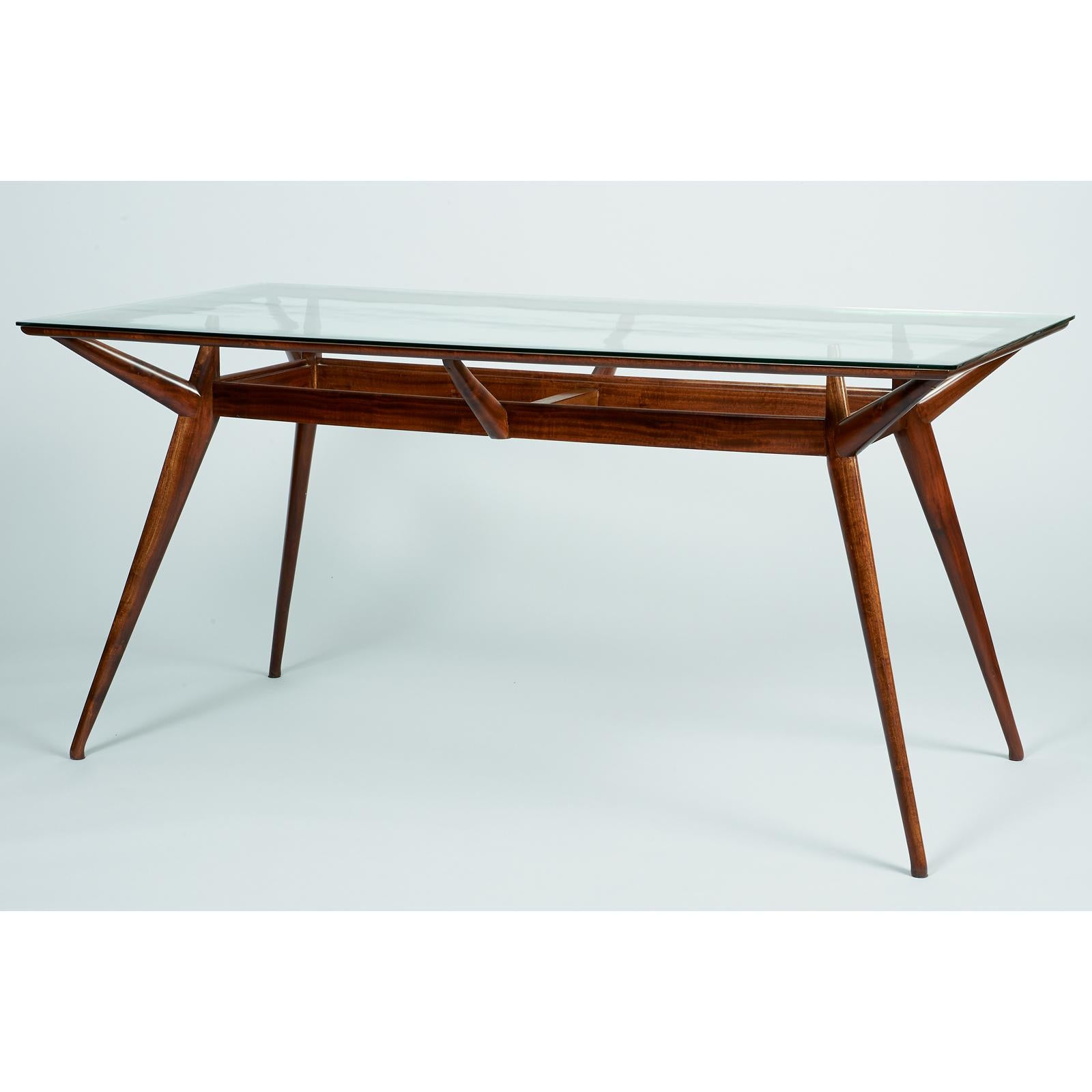 Silvio Cavatorta (1899-1957)

A superb rectangular organic modernist dining table by Italian designer Silvio Cavatorta, with an inset glass top with a delicate internal ripple effect, resting in a two-tiered and sharply angled mahogany frame