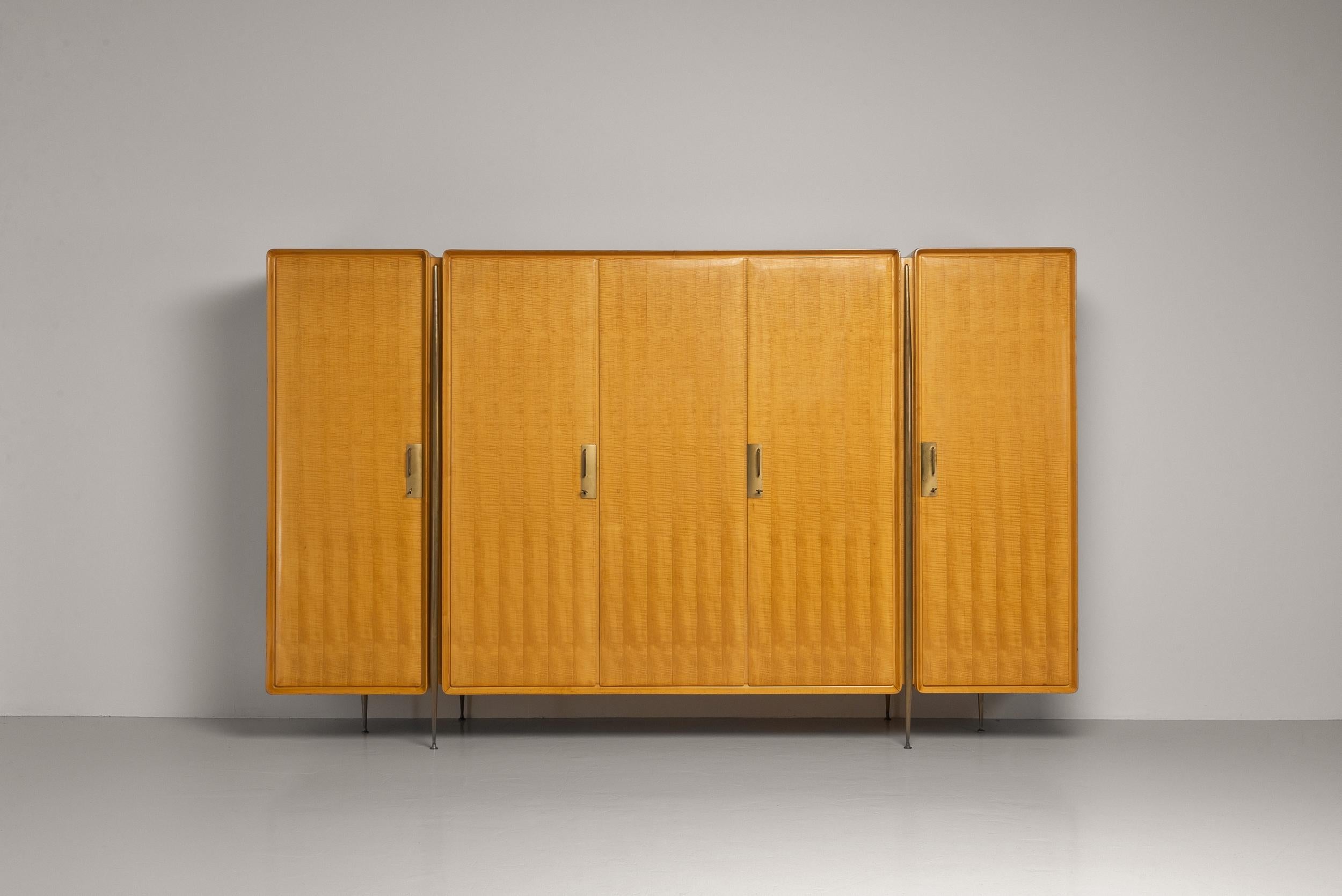 Exceptional wardrobe created by the renowned furniture designer Silvio Cavatorta in Italy 1958. This cabinet is made from beautiful maple wood with a glossy finish that gives it a polished and sophisticated appearance. The wood's natural tones