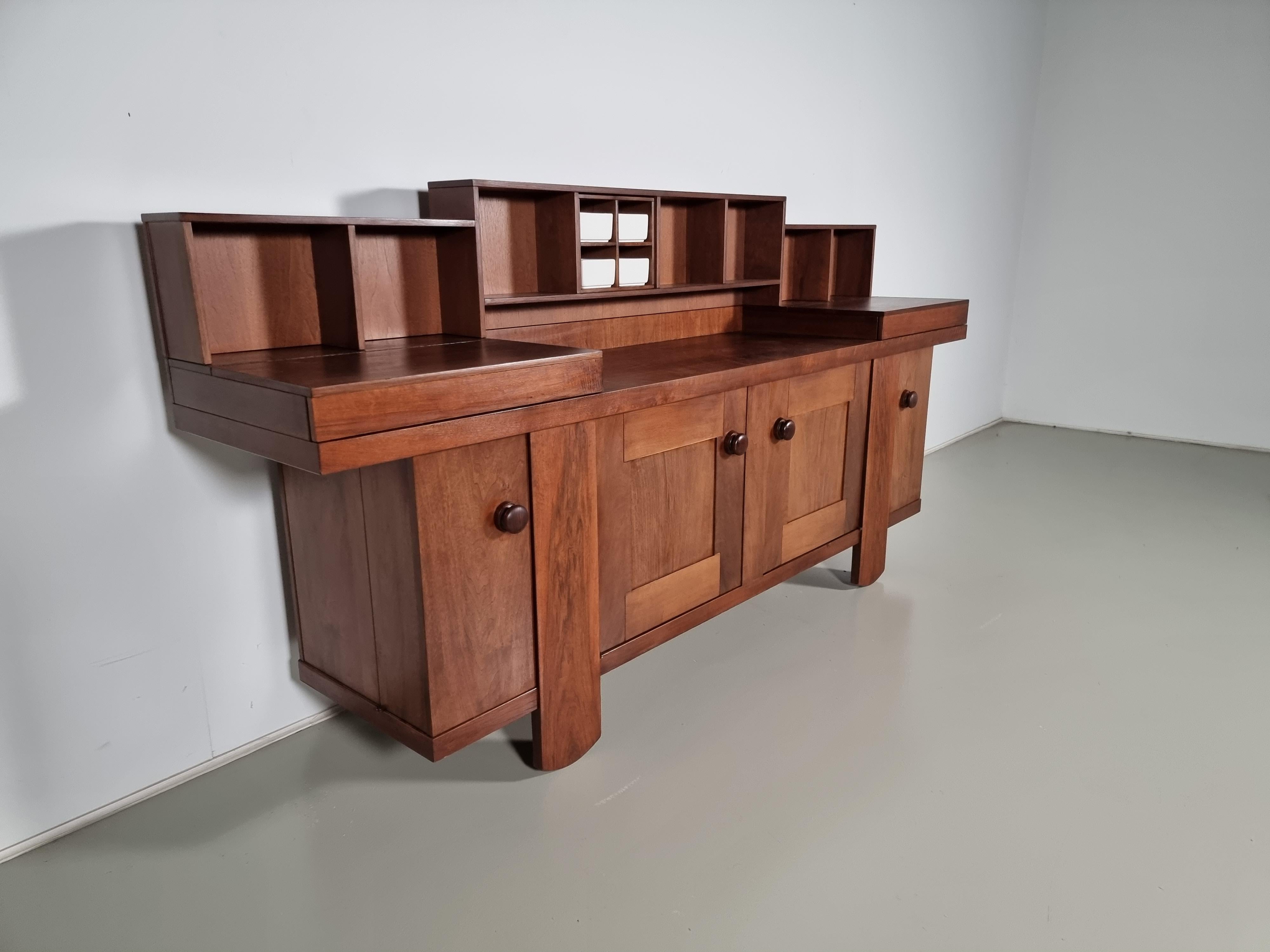 Wonderful sideboard designed by Silvio Coppola for Bernini in 1968. The structure is in walnut wood and has eight compartments of the same size, a compartment for porcelain vases, two lined trays with drop-down doors, two central doors, two corner