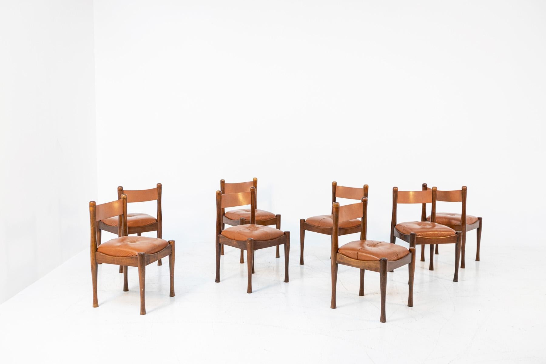 Set of eight Italian dining chairs from the 1960s designed by Silvio Coppola for the Bernini manufacture. The chairs are made of beech wood. The seat is made of cushion with light brown leather upholstery with central button. The back is made with a