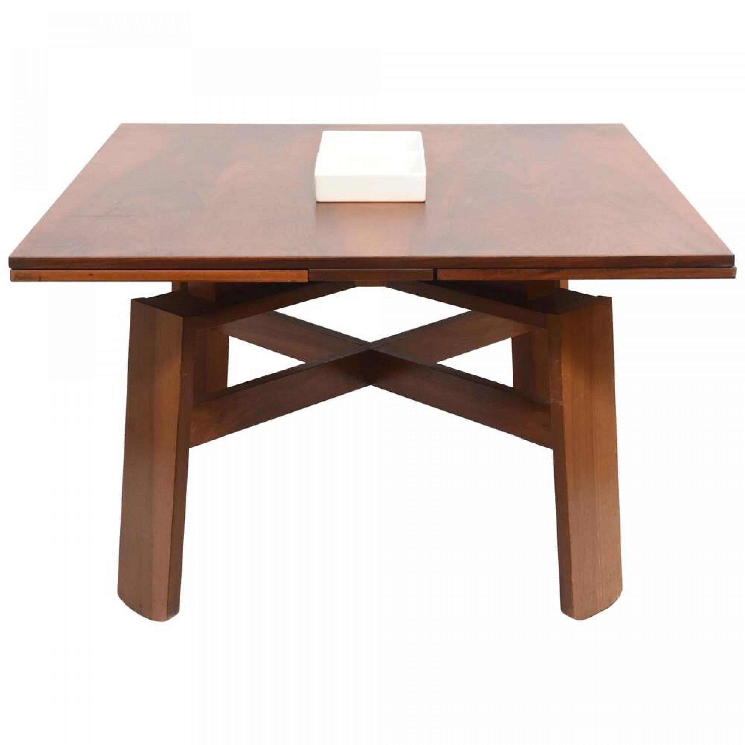 Italian Mid-Century Modern extension table with two fold out leaves resting on four wide legs connected with an x-shaped stretcher.(SILVIO COPPOLA).