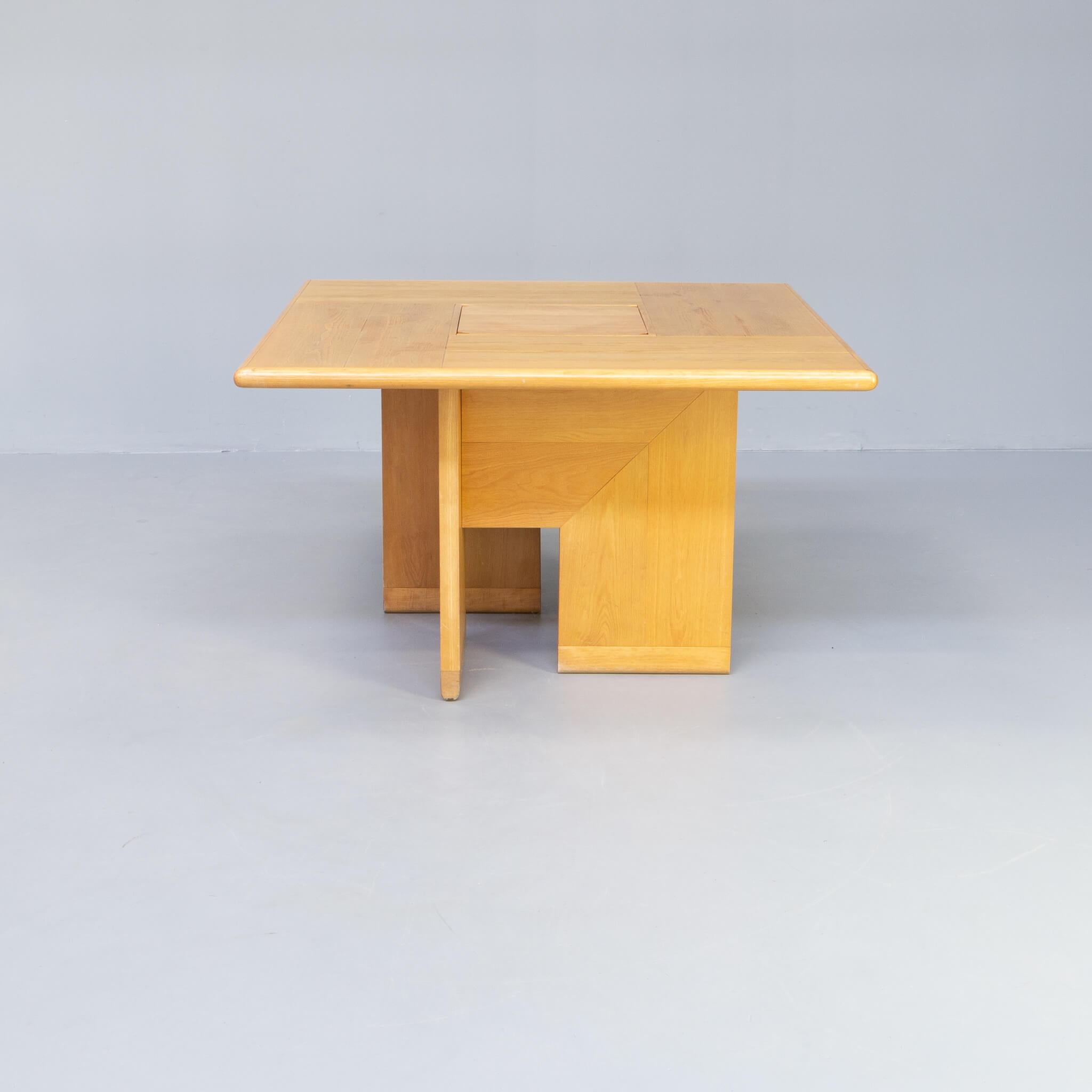 This square dining table has a remarkable wooden lined foot that consists of four beautifully lined wooden elements, carried on 1 rounded wooden bar, that all four fit together with a for that time progressive metal click system. The four parts