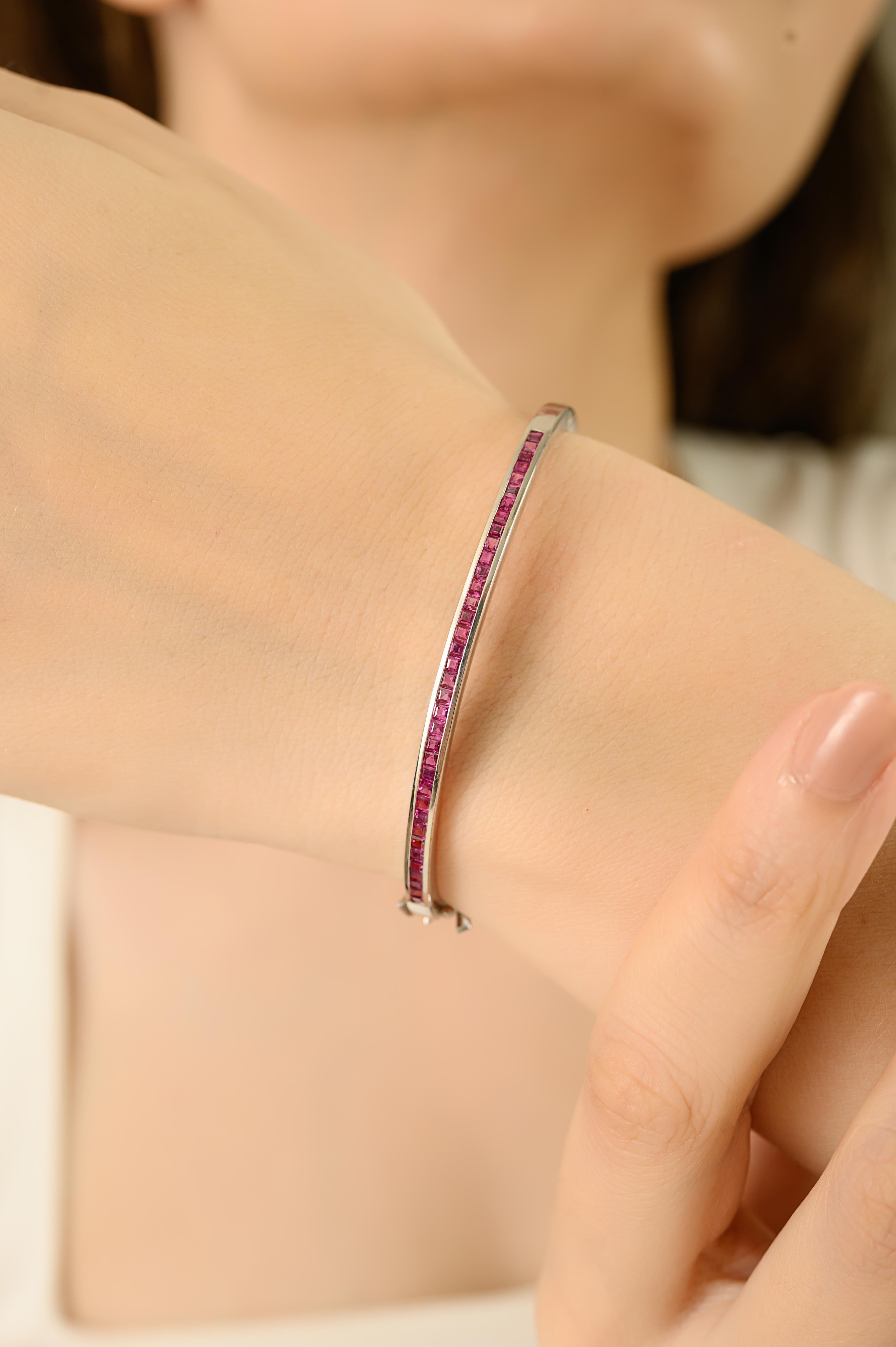 This exquisite bangle bracelet is crafted from premium 925 sterling silver and showcases a sleek row of 36 vibrant, square-cut ruby gemstones. Each ruby measures 2x2 mm, with a collective weight of 1.6 carats, creating a striking yet refined