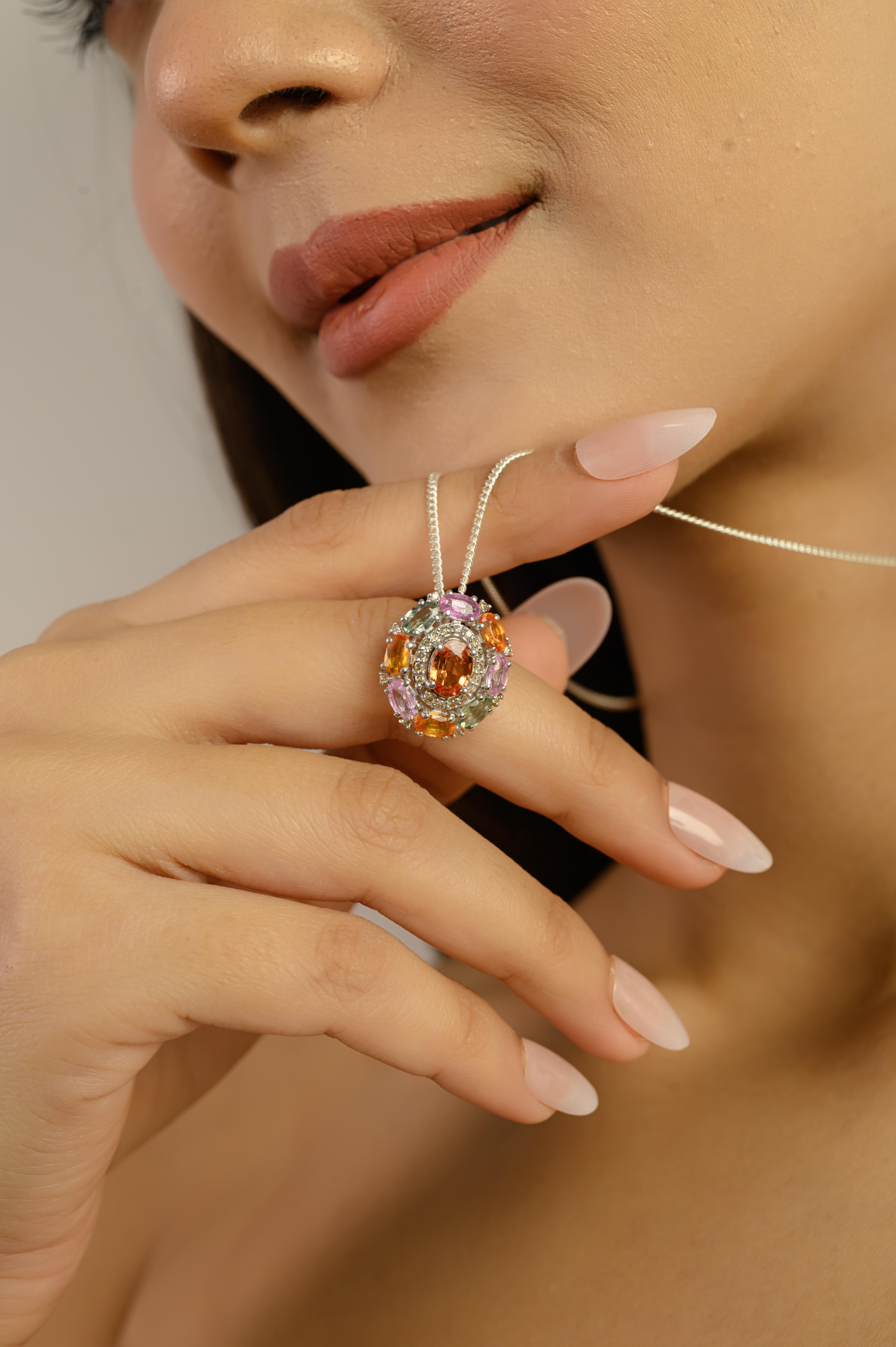 Questo ciondolo è realizzato in argento sterling 925,  mostra un radioso insieme di zaffiri naturali multicolore e diamanti scintillanti. Presenta nove zaffiri ovali e rotondi di 7x5 mm e 5x3 mm, per un peso totale di 4,65 carati. Intorno agli