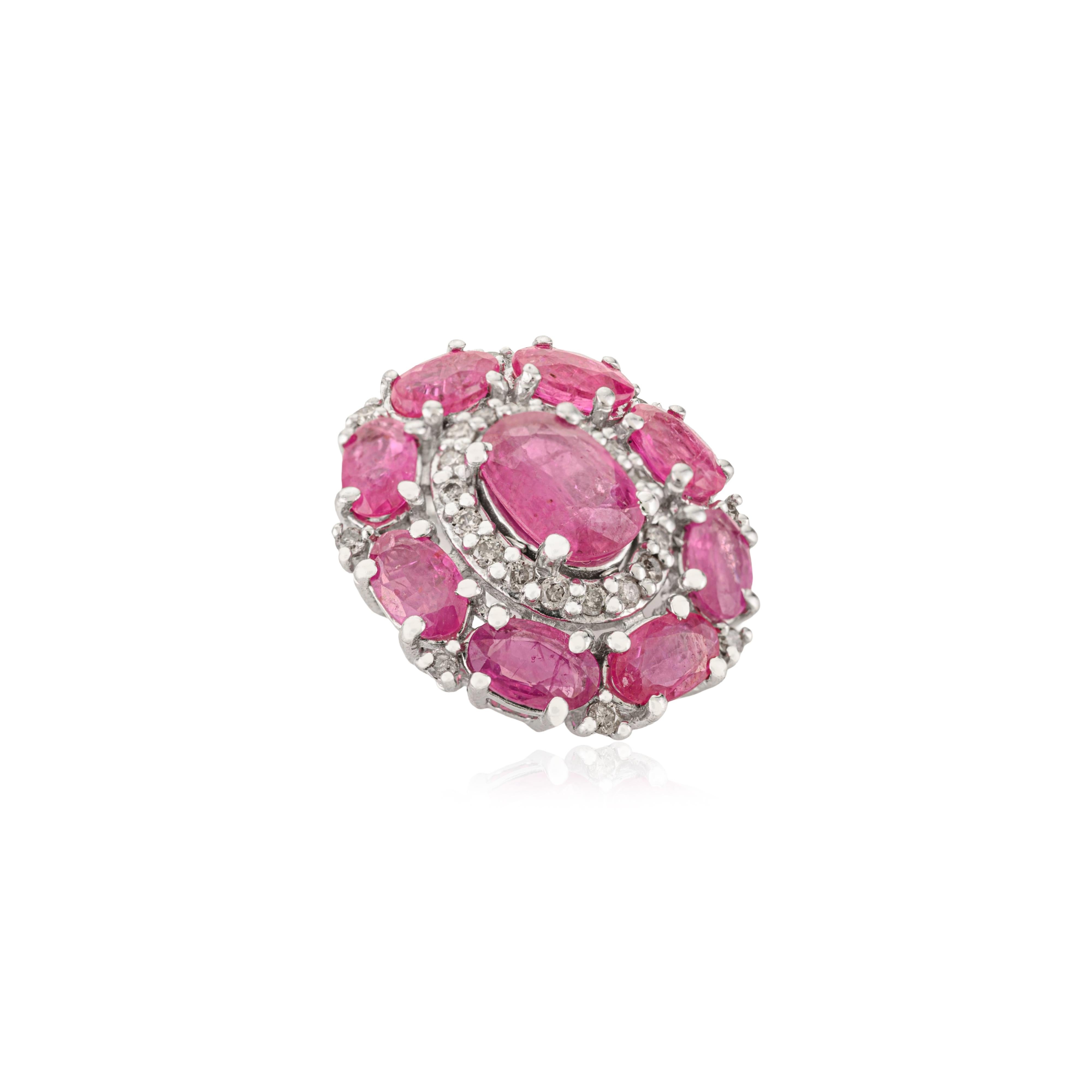 Questo ciondolo in argento 925 presenta al centro un grande rubino naturale ovale di 7x5 mm, circondato da otto rubini più piccoli di forma rotonda di 5x3 mm, per un totale di 4,65 carati di rubini. I diamanti bianchi scintillanti, ciascuno di 1,3