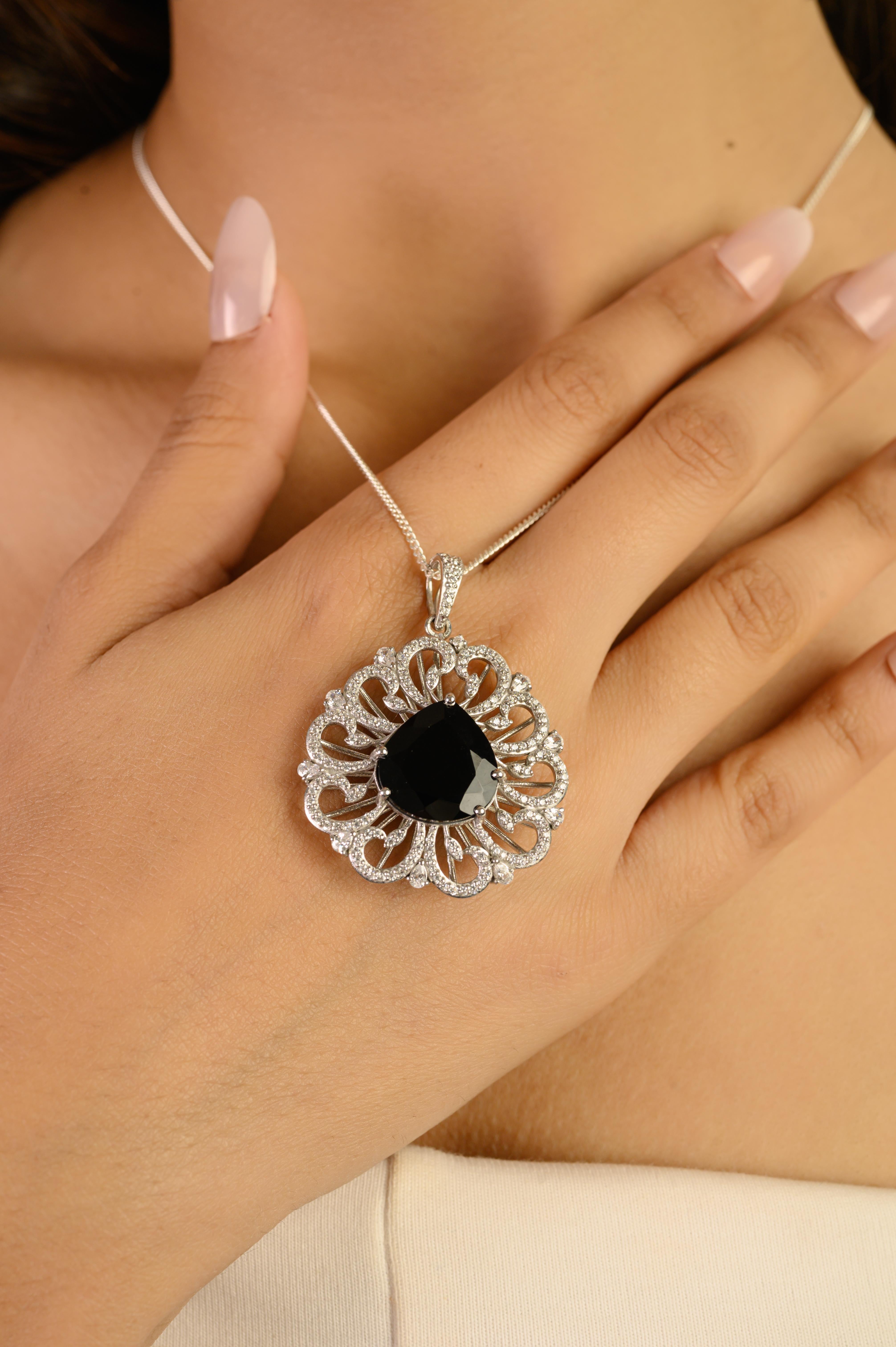 Questo ciondolo in argento 925 è caratterizzato da un'unica gemma di onice nero naturale a forma di pera di 15x14 mm e 8,8 carati di peso. L'audace centro è incorniciato da un'elegante aureola traforata ornata da scintillanti zirconi bianchi, che