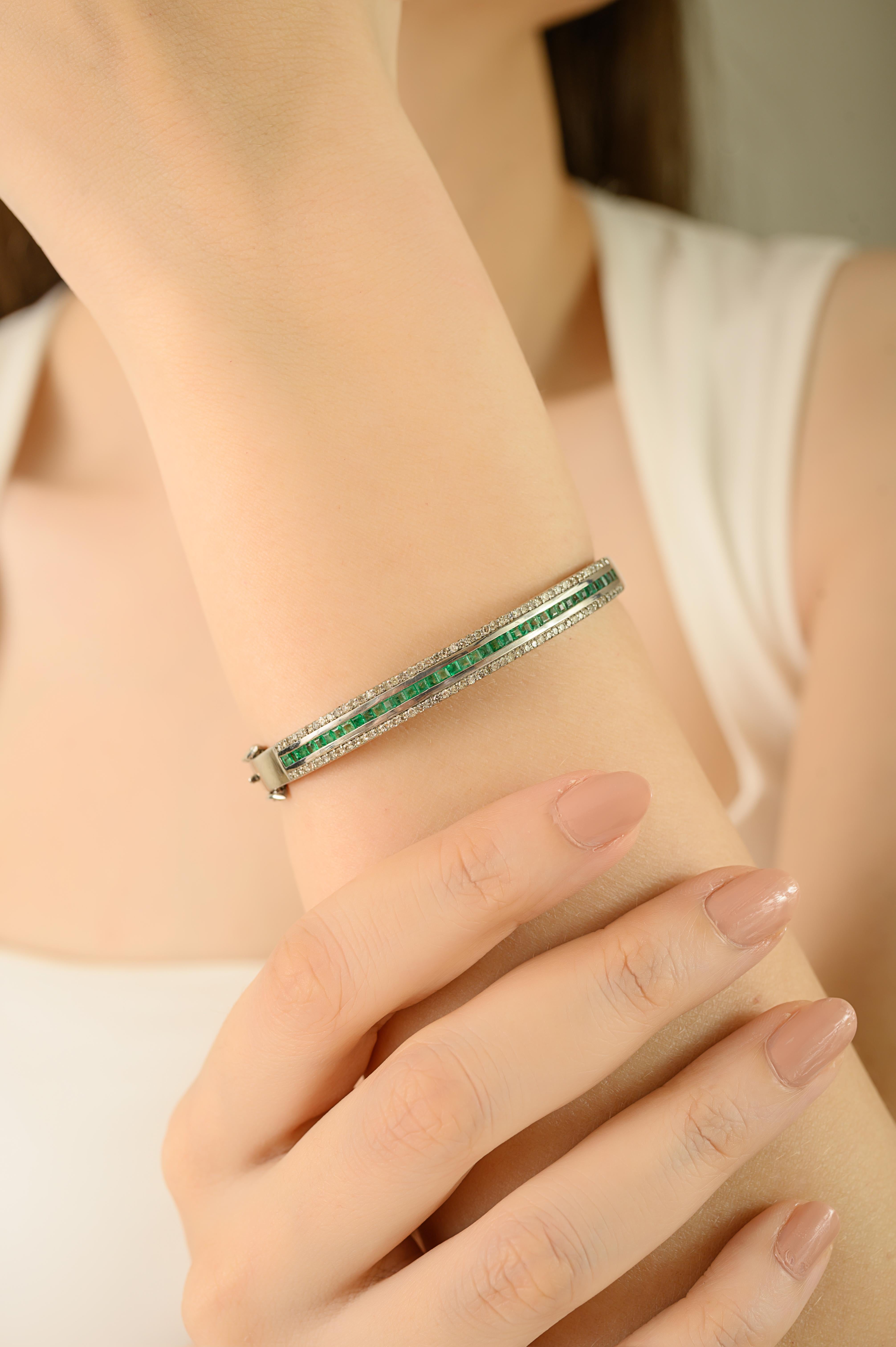 This Modern bangle bracelet  is crafted in 925 sterling silver, featuring square cut emeralds weighing 1.40 carats and sparkling diamonds totaling 0.90 carats. The emeralds are set in sleek bezels, while the diamonds are prong-set for brilliance and