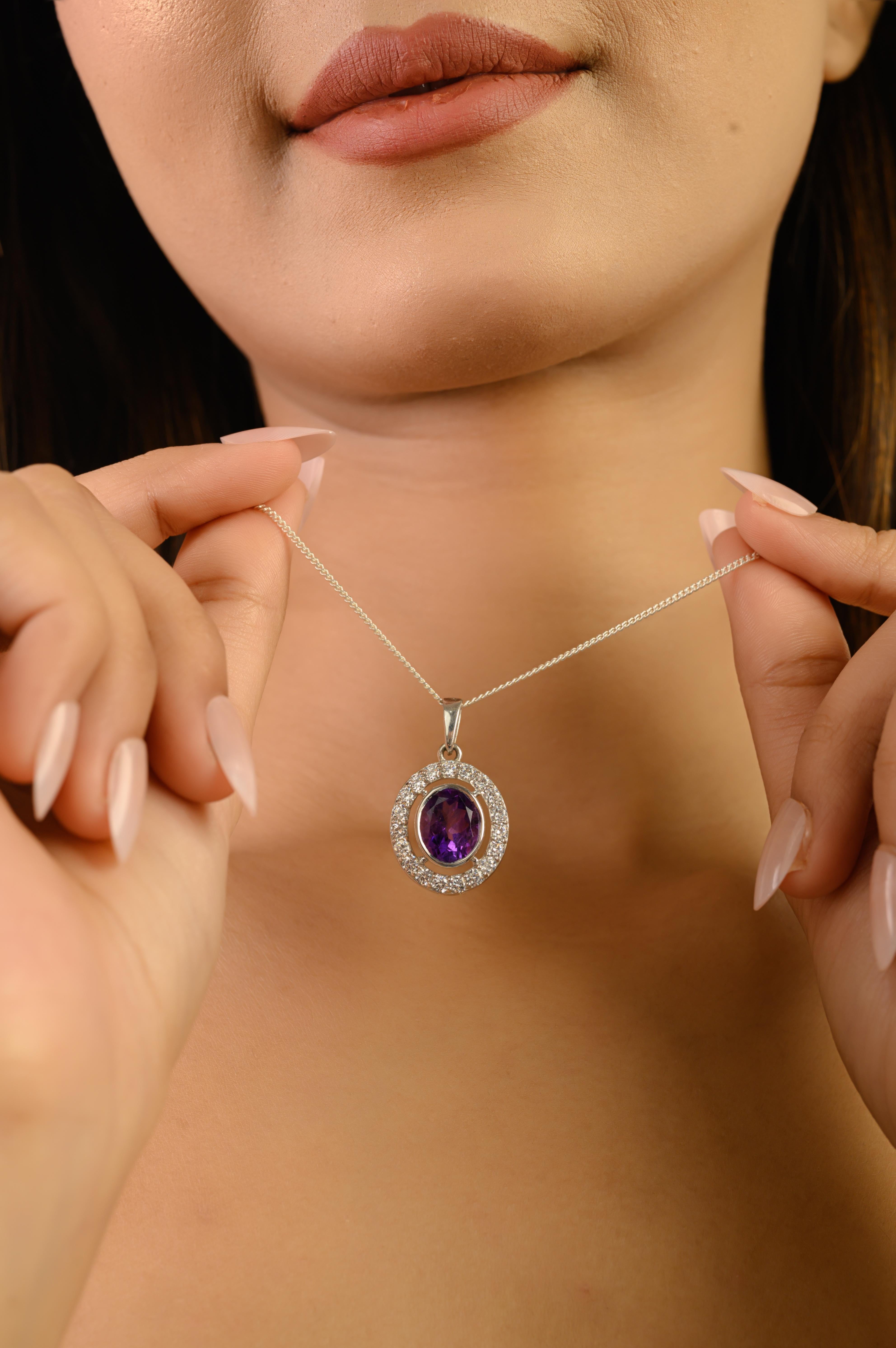 Questo elegante ciondolo in argento sterling 925 ha come fulcro un'ametista naturale dal taglio ovale. L'ametista di 9x7 mm e 11,88 carati mostra una ricca tonalità violacea, splendidamente evidenziata da zirconi bianchi scintillanti di 1,9 mm che