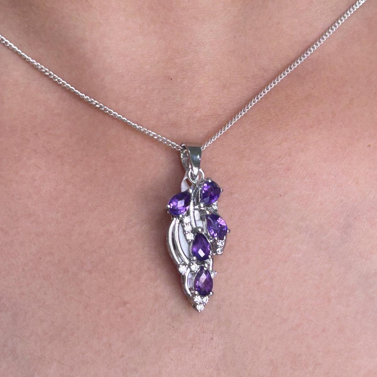 Questo elegante ciondolo presenta cinque gemme di ametista naturale, ciascuna sapientemente tagliata a forma di pera di 6,9 x 4 mm. Le gemme, incastonate in un brillante argento sterling 925, hanno un totale di 2,35 carati e creano una vibrante