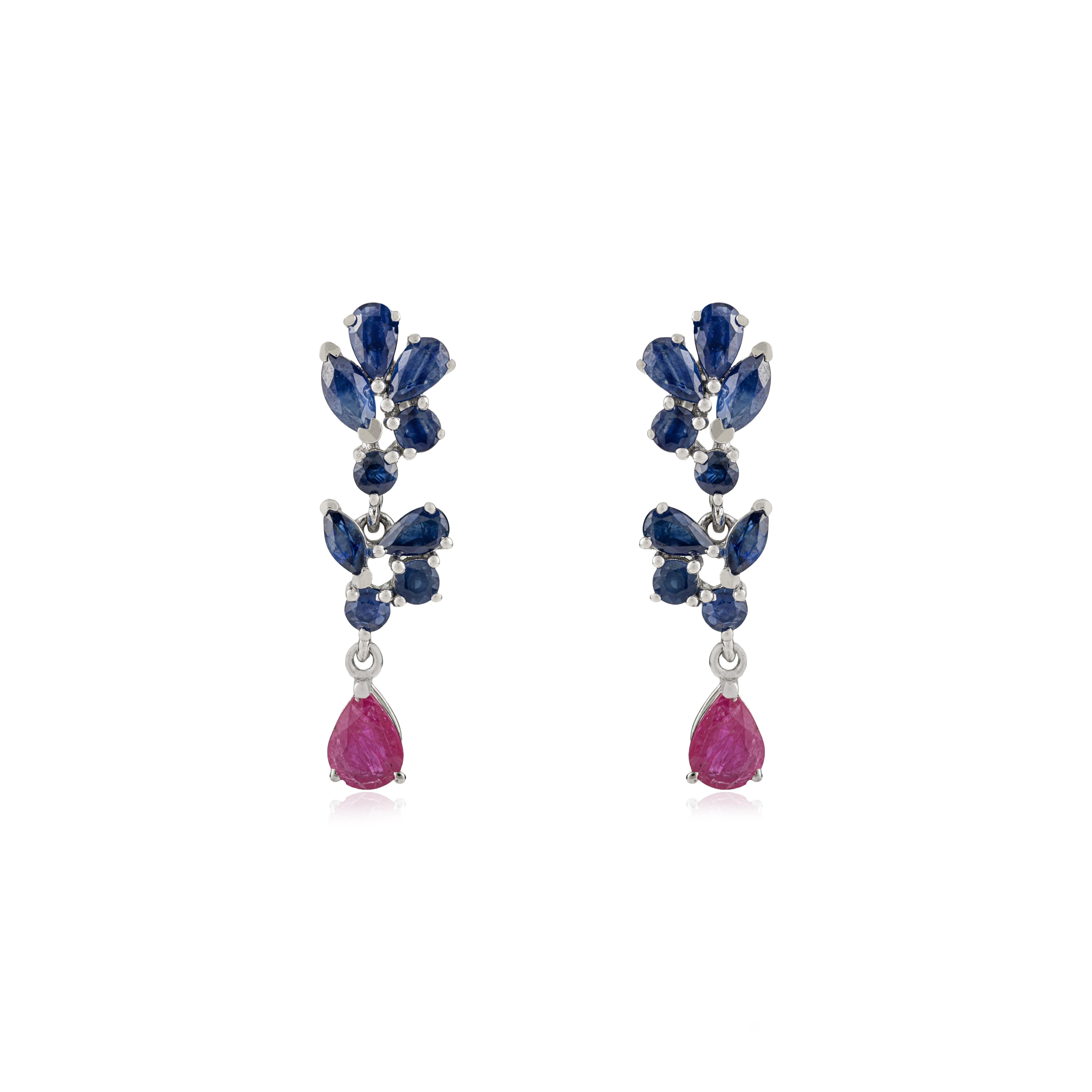 Crafted in 925 sterling silver, these elegant dangle earrings feature a vibrant arrangement of natural blue sapphires and rubies. Twenty mixed-shape gemstones, totaling 4.91 carats, form a striking interplay of cool and warm tones within a refined