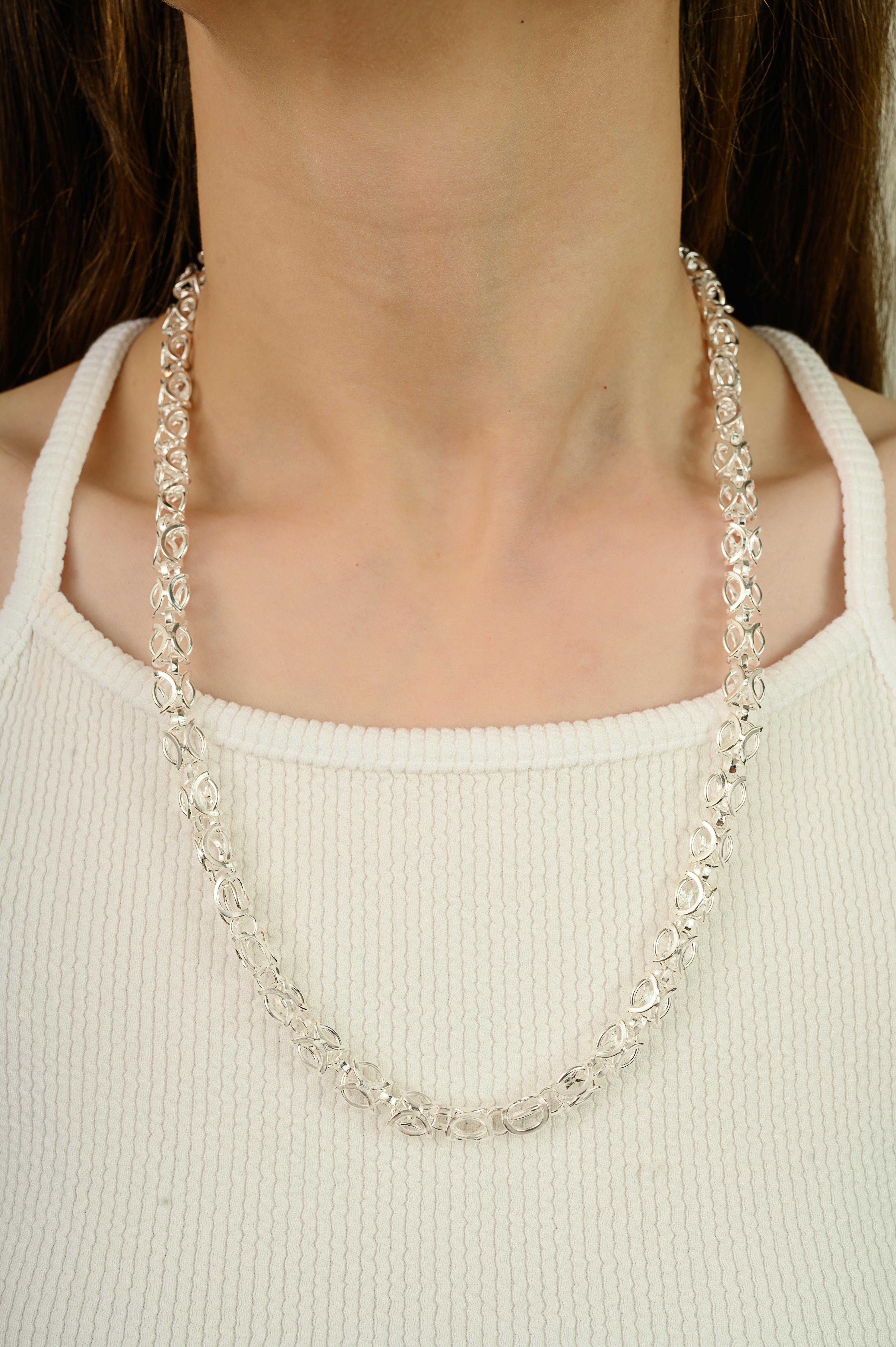 A striking link chain necklace crafted from pure 925 sterling silver, designed with an intricate interwoven pattern that emphasizes strength and style. Weighing 58.4 grams, it offers a bold presence when worn. The necklace measures 23.5 inches in
