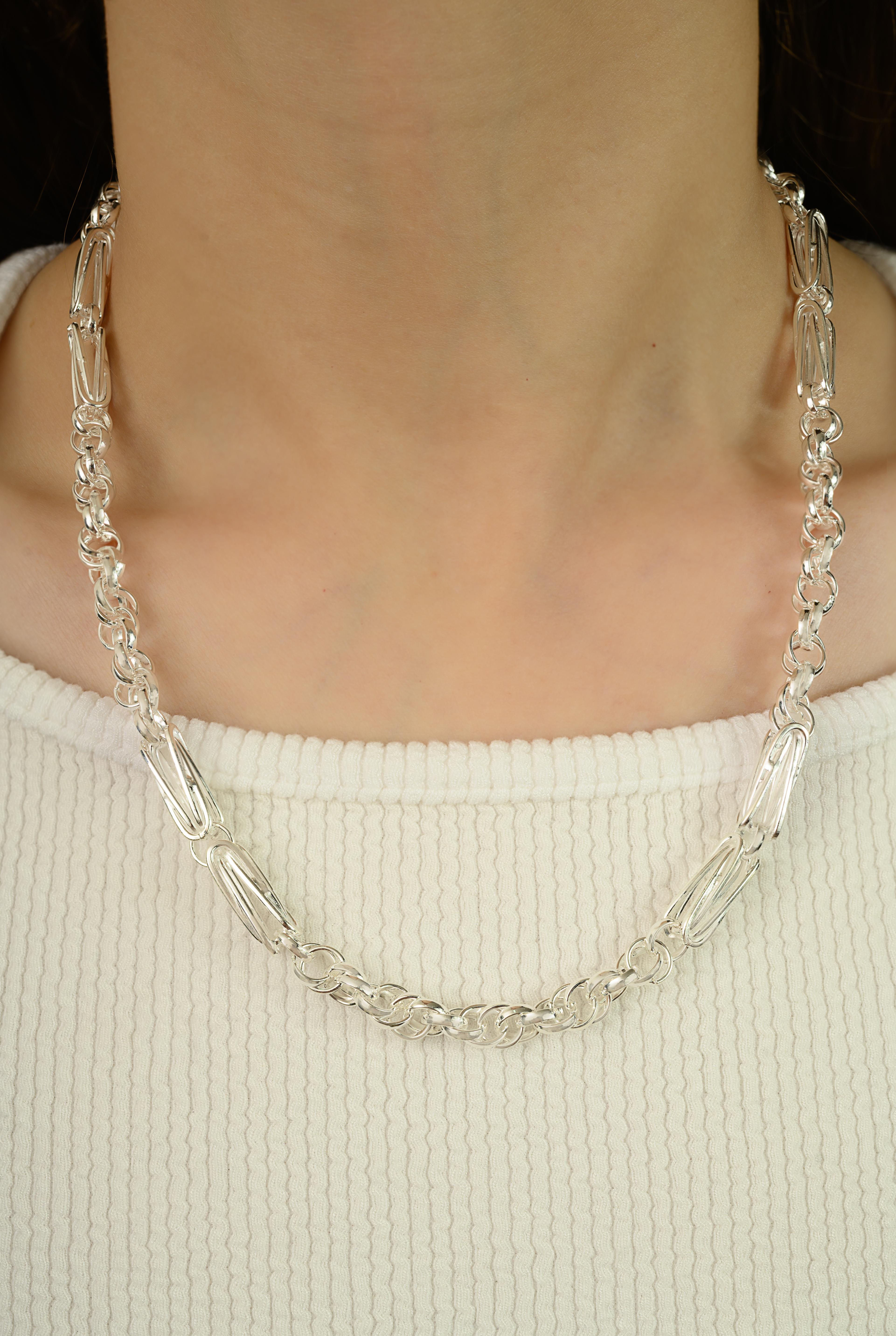 Realizzata in puro argento 925, questa raffinata collana presenta maglie allungate e intricate che incarnano un lusso audace e senza tempo. Con un peso di 48,8 grammi, rappresenta il perfetto equilibrio tra forza ed eleganza raffinata. Con una