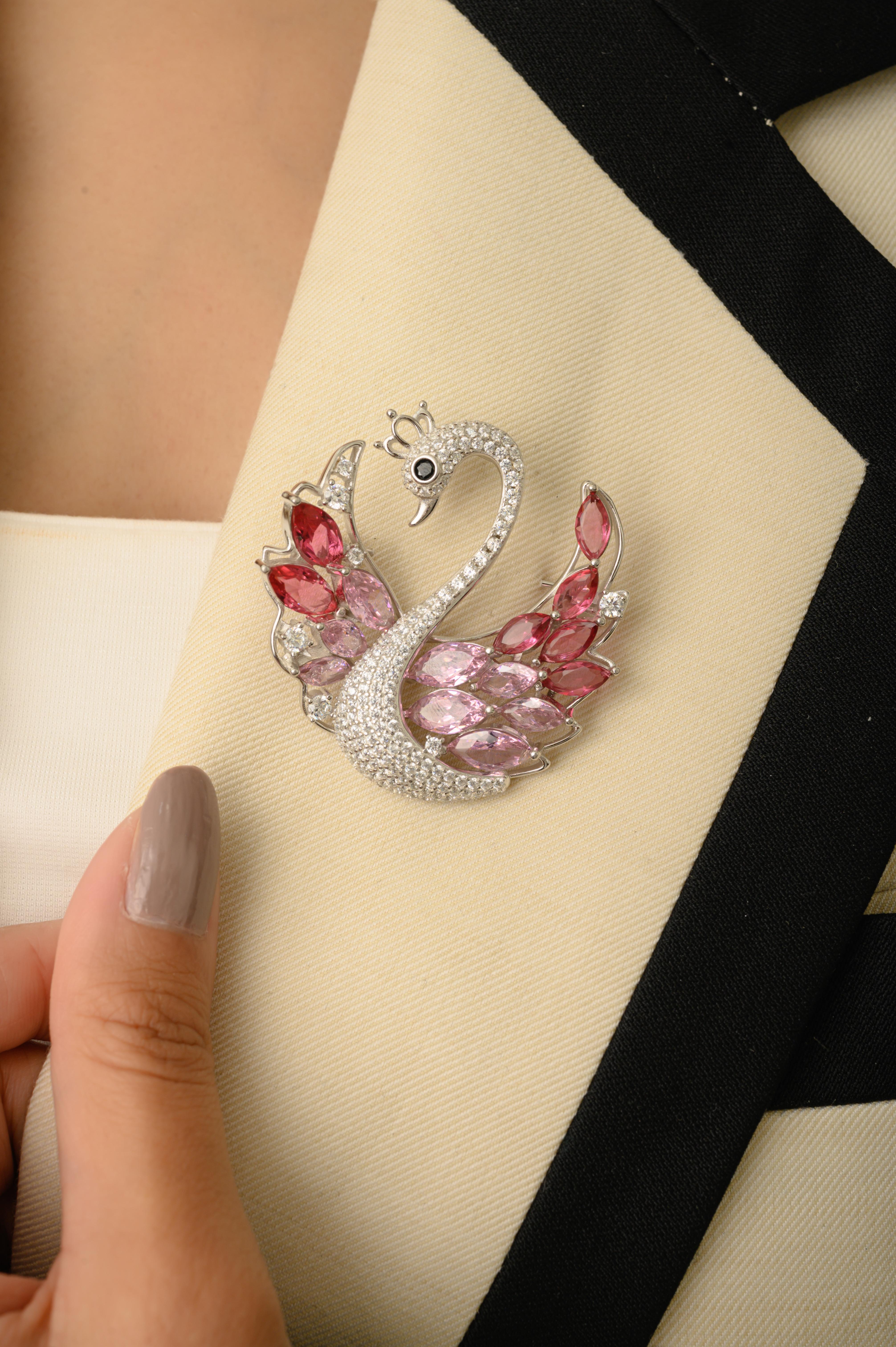 Este exquisito colgante broche de Silvorra presenta un precioso diseño de cisne en plata de ley 925 de primera calidad. Las alas del cisne están engastadas con una llamativa combinación de piedras de circonita rosa y blanca en talla marquesa,