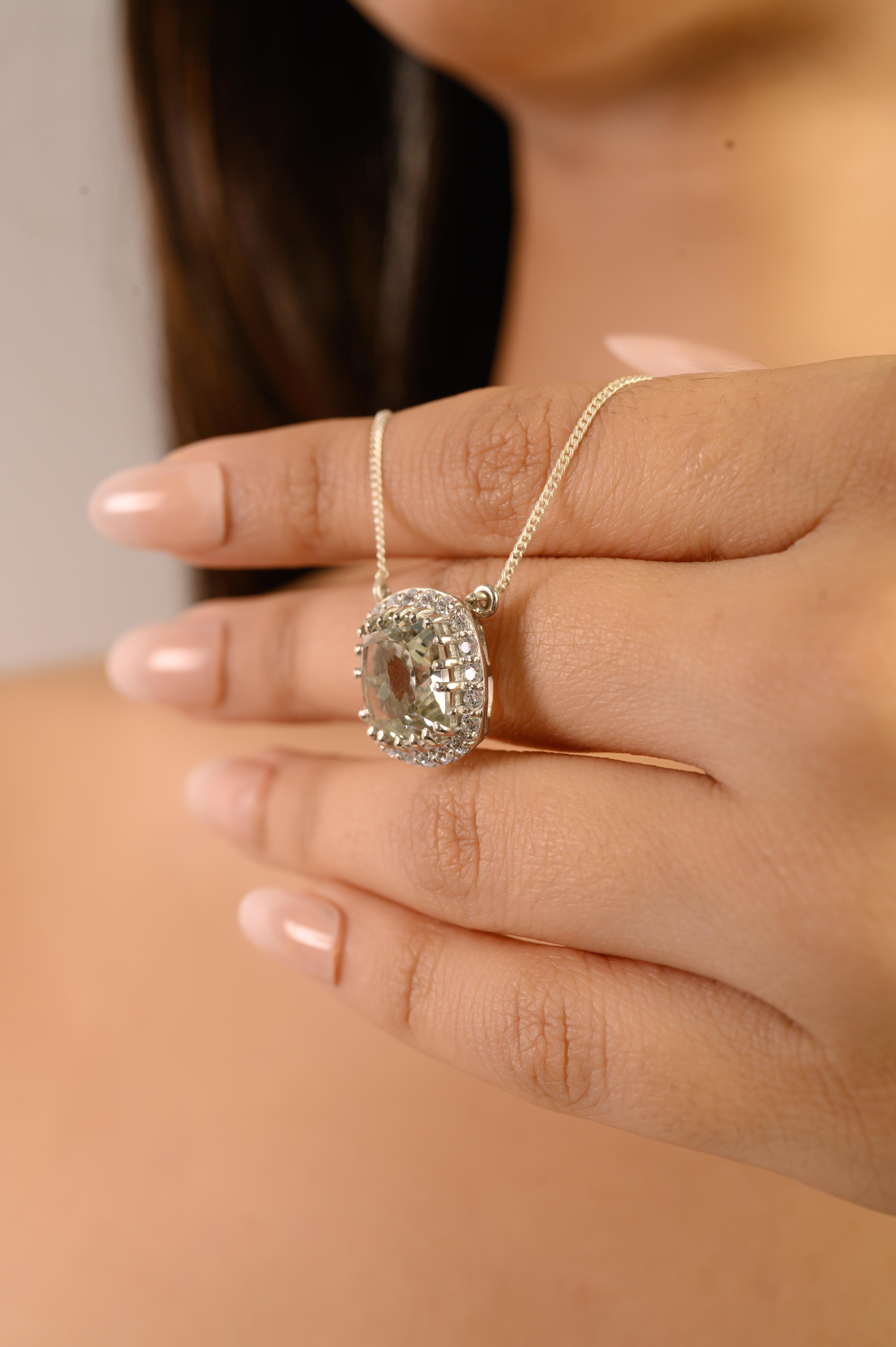 This elegant 925 sterling silver pendant necklace centers a natural cushion-cut green amethyst, framed by a bright white zircon halo for classic sparkle. The pastel-green gemstone measures 12 x 12 mm and weighs approximately 6.55 carats, offering a