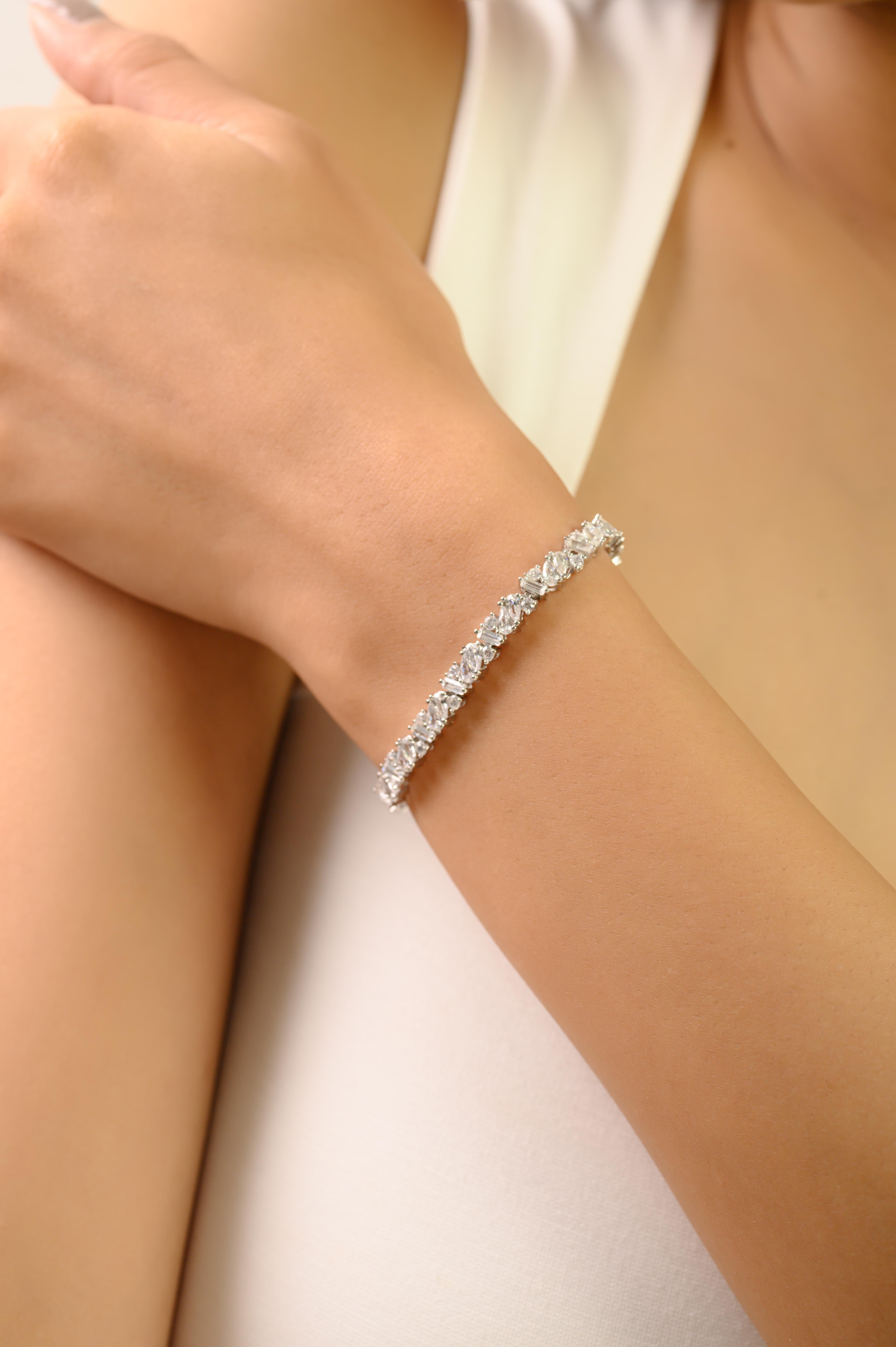 Questo squisito braccialetto di Silvorra è realizzato in argento sterling 925 e impreziosito da splendide pietre di zirconia cubica bianca di dimensioni e tagli diversi. L'abile combinazione di pietre a pera, marquise, baguette e rotonde crea uno