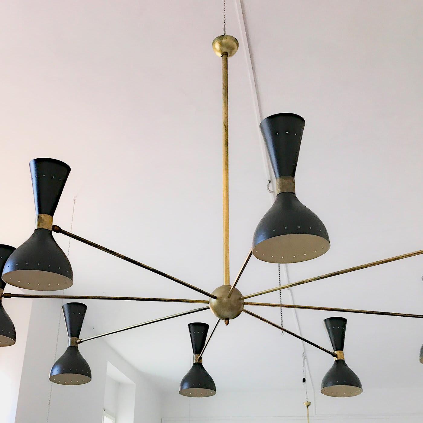 Modern and sophisticated, this chandelier is the ideal choice to make a statement in a modern dining or living room. Its natural solid brass structure comprises a central stem from which radiate eight arms. The aluminum shades are 12.5 cm long with