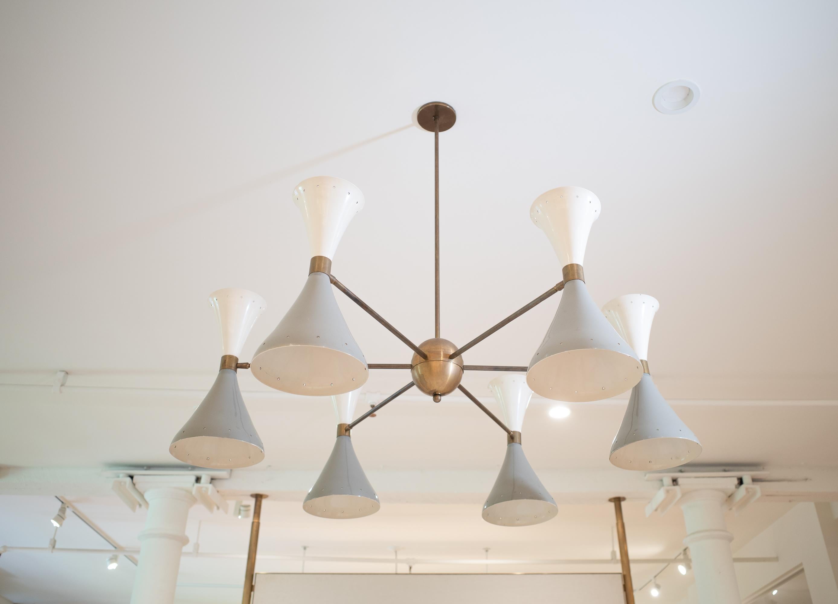 A quintessential piece of Italian Mid-Century Modern lighting, this version of the “Simmetrico” cluster chandelier by the esteemed manufacturer Stilnovo dates to the 1950s. The dynamic, yet balanced fixture is defined by its six elements, each