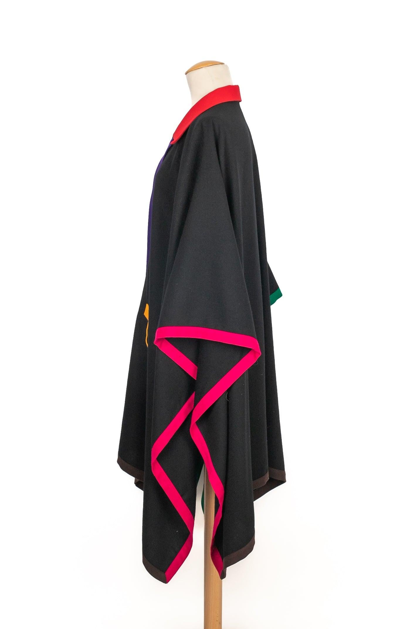 Simon Chang - Black wool shirt-style coat/cape edged with red, yellow, green, and pink. No size indicated, it fits a single-size. To be mentioned, a button is missing.

Additional information:
Condition: Good condition
Dimensions: Width: 136 cm -