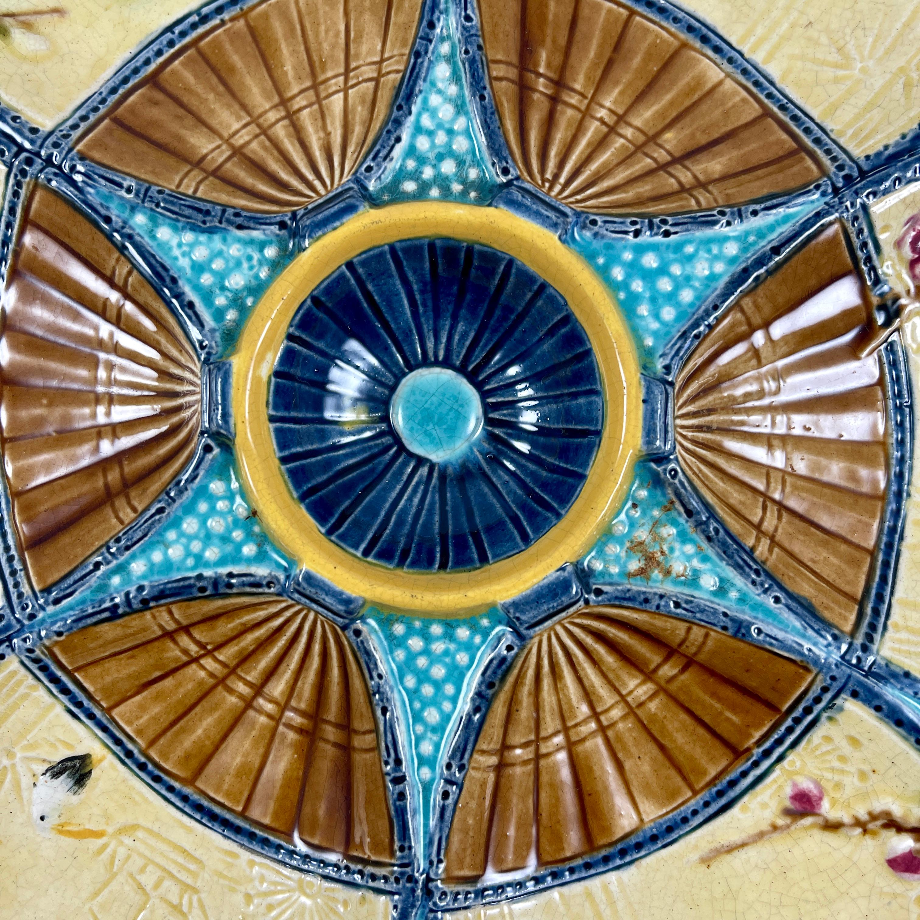 A six-well majolica glazed oyster plate by Simon Fielding, Stoke-on-Trent, England, circa 1878.

In the Japonisme taste, six fan shaped oyster wells glazed in a creamy yellow and chocolate brown sit on a textured turquoise ground. The fans extend