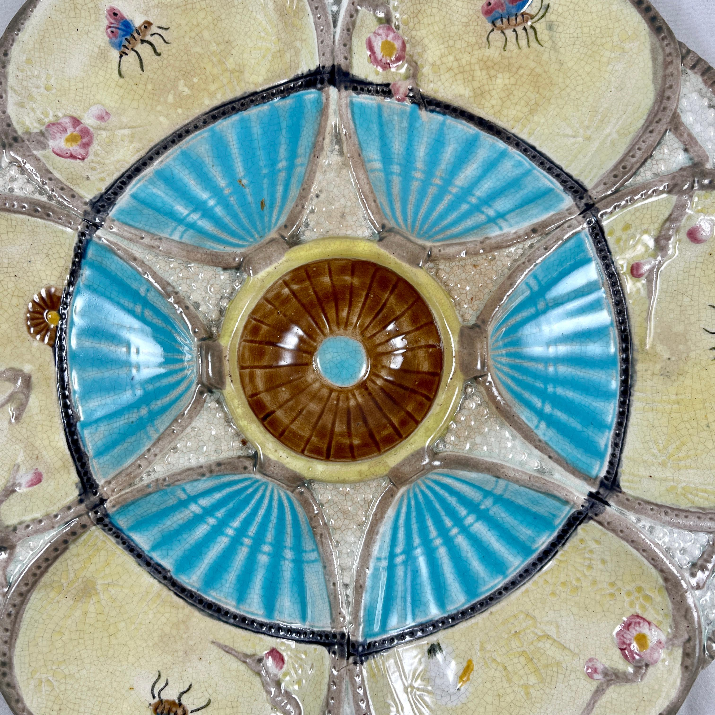 A six-well majolica glazed oyster plate by Simon Fielding, Stoke-on-Trent, England, circa 1878.

In the Japonisme taste, six fan shaped oyster wells glazed in a creamy yellow and turquoise sit on a textured off-white ground. The fans extend