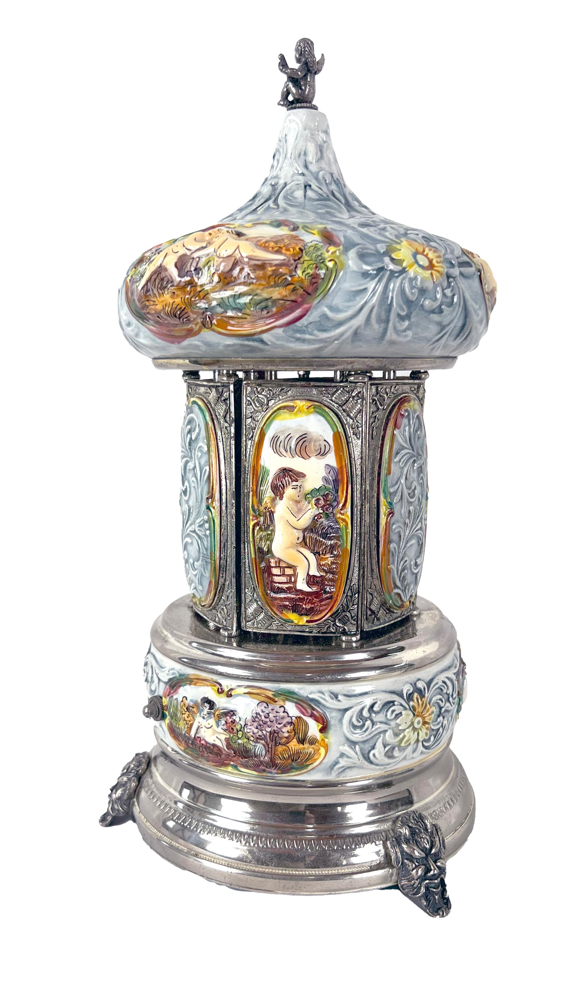 Simo, Florence Italy Musical Lipstick Carousel - Capodimonte Porcelain Cherubs

Italian lipstick carousel with a Porcelain works Simo, Florence Italy with a Swiss Reuge music box, and hand painted Capodimonte porcelain cherubs. Silver plated.
