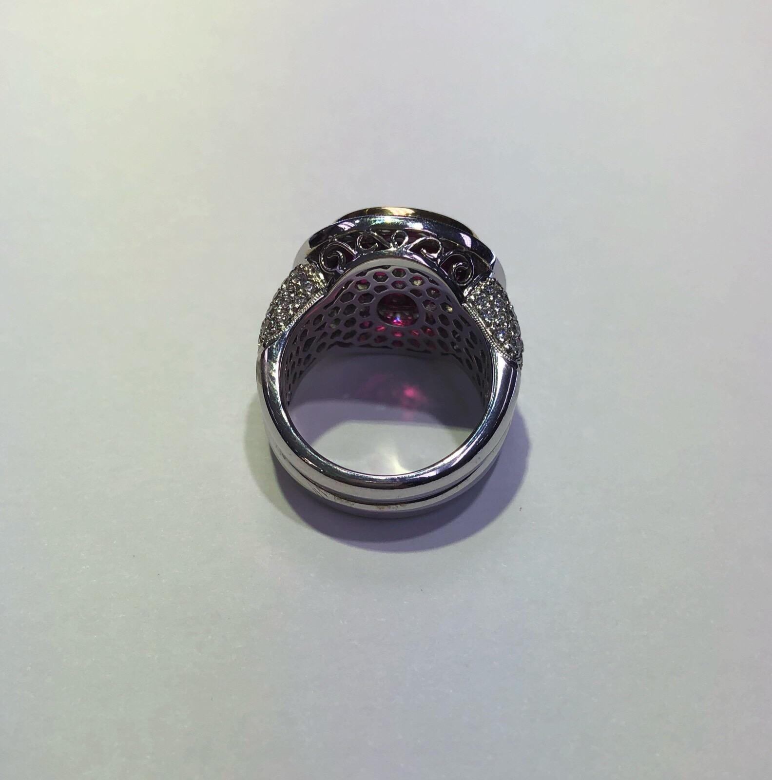 18k white and yellow gold Simon G ring set with one 5.98 carat oval cut rubelite center and 1.36 carats total weight of round brilliant diamonds. Ring size is 6.5 