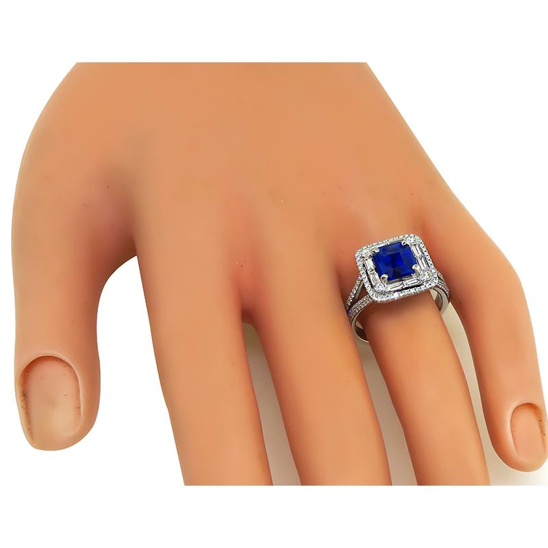 This is an elegant 18k white gold engagement ring by Simon G. The ring is centered with a lovely AGL certified natural no heat asscher cut sapphire that weighs 1.76ct. The sapphire is accentuated by sparkling baguette and round cut diamonds that