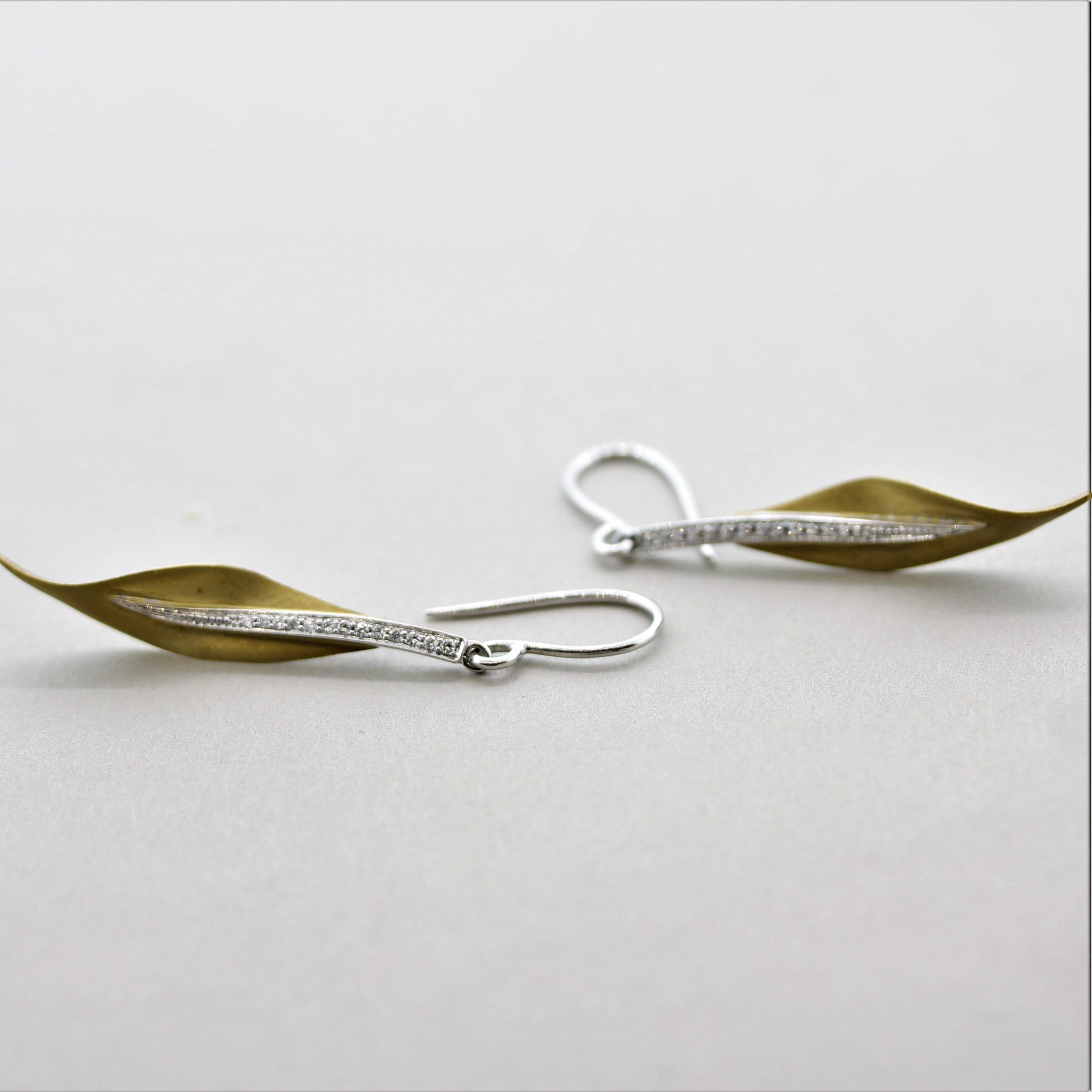 A stylish pair of earrings by designer Simon G! They feature 0.13 carats of fine round brilliant-cut diamonds set on the stems of this life-like leaf design. Made in both 18k white & yellow gold with a satin brush finish, these realistic earrings