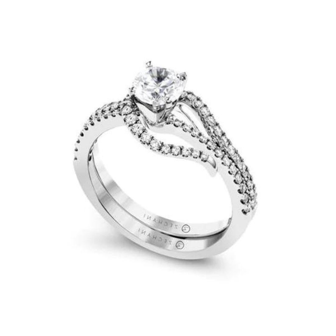 This bold 14k white gold design features a wedding band which loops around the engagement setting, and together they contain 0.39 ctw of round white diamonds, G color, VS2 clarity. Created for Zeghani collection by couture bridal designer Simon G.