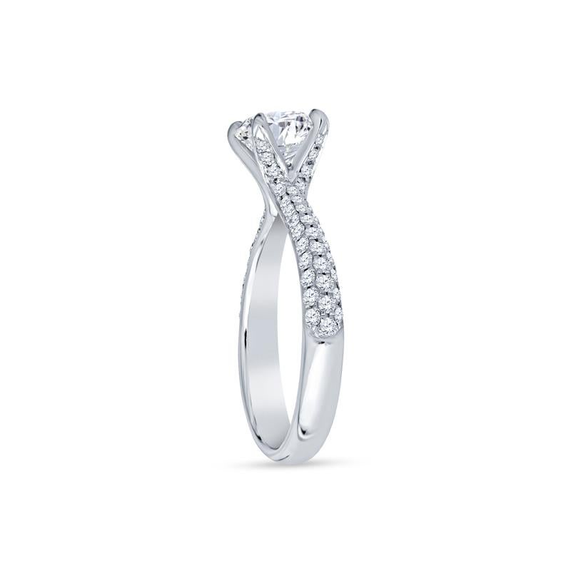 Cette bague de fiançailles exquise de Simon G. est ornée d'un diamant rond de taille brillant de 0,85ct certifié par le GIA, magnifiquement entouré de 0,40ct de diamants ronds d'accentuation. Fabriquée en or blanc 18 carats, cette bague offre une