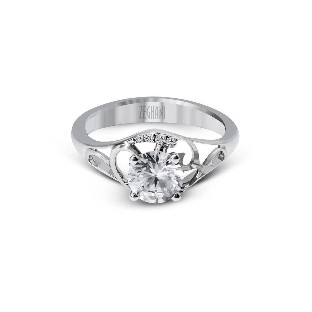 This airy diamond engagement mounting features a delicate open filigree pattern within a split shank. Ring contains 0.06ctw of round white diamonds, G color, VS2 clarity, set in 14k white gold. Ring is part of the Zeghani collection by couture