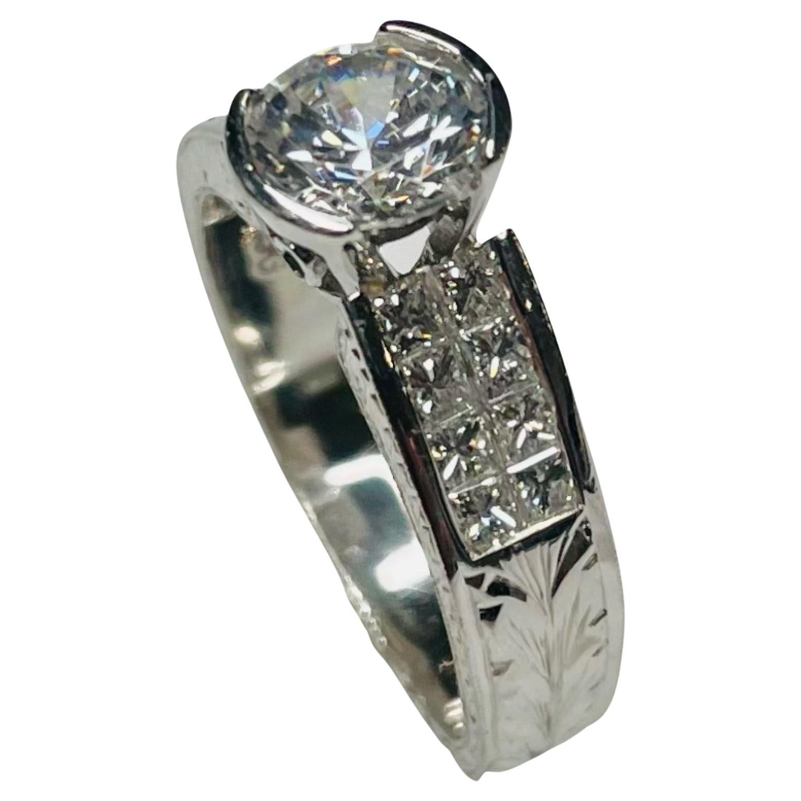 Simon G Platinum Invisible Set Engagement Ring. It has a 6.5mm Cubic Zirconia Center, which is equivalent to a 1.0 carat diamond size. It is set in a half bezel. This CZ can be replaced with a colored stone, moissanite or lab created or natural