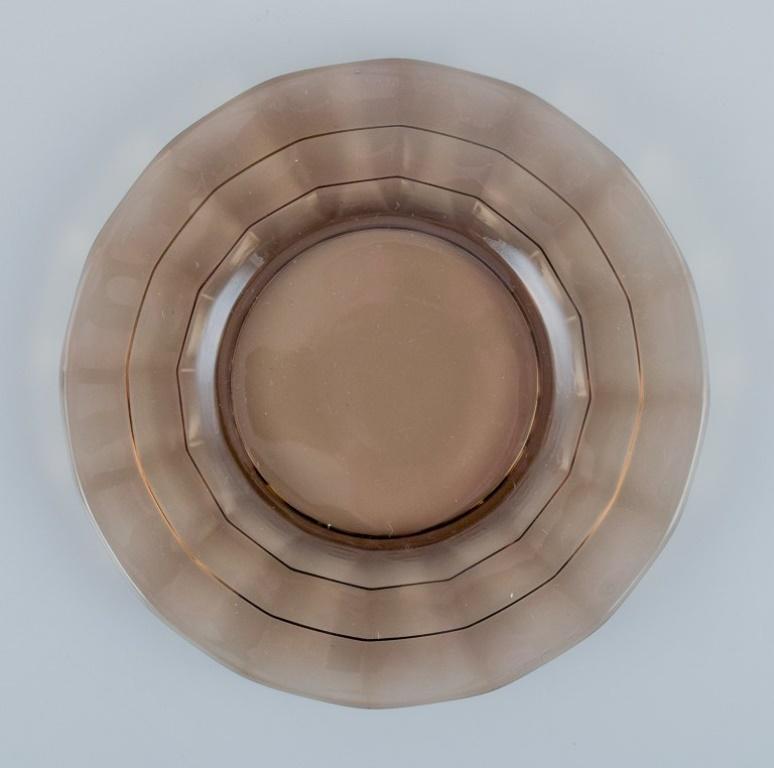 Simon Gate (1883-1945) for Orrefors/Sandvik, Sweden.
A set of thirteen small Art Deco plates in smoked-coloured pressed glass.
Model G756.
Ca. 1940.
Perfect condition.
Dimensions: D 15.7 cm.