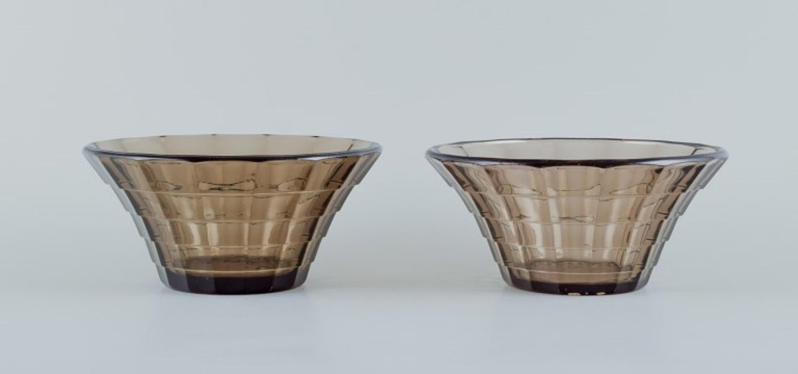 Simon Gate (1883-1945) for Orrefors/Sandvik, Sweden.
Two Art Deco bowls in smoked-coloured pressed glass.
Model G756.
Ca. 1940.
In perfect condition.
Dimensions: D 16.3 cm x H 8.2 cm.