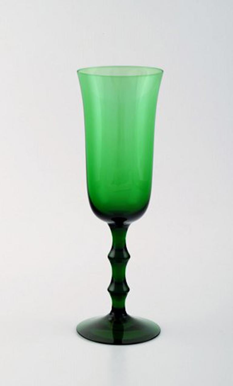 Simon Gate Orrefors, A set of 12 green champagne glasses in art glass. 
Designer: Simon Gate
Series: Salut
Producer: Orrefors
Country: Sweden
Designed: 1923
Size: Height 19 cm, diameter 6 cm.