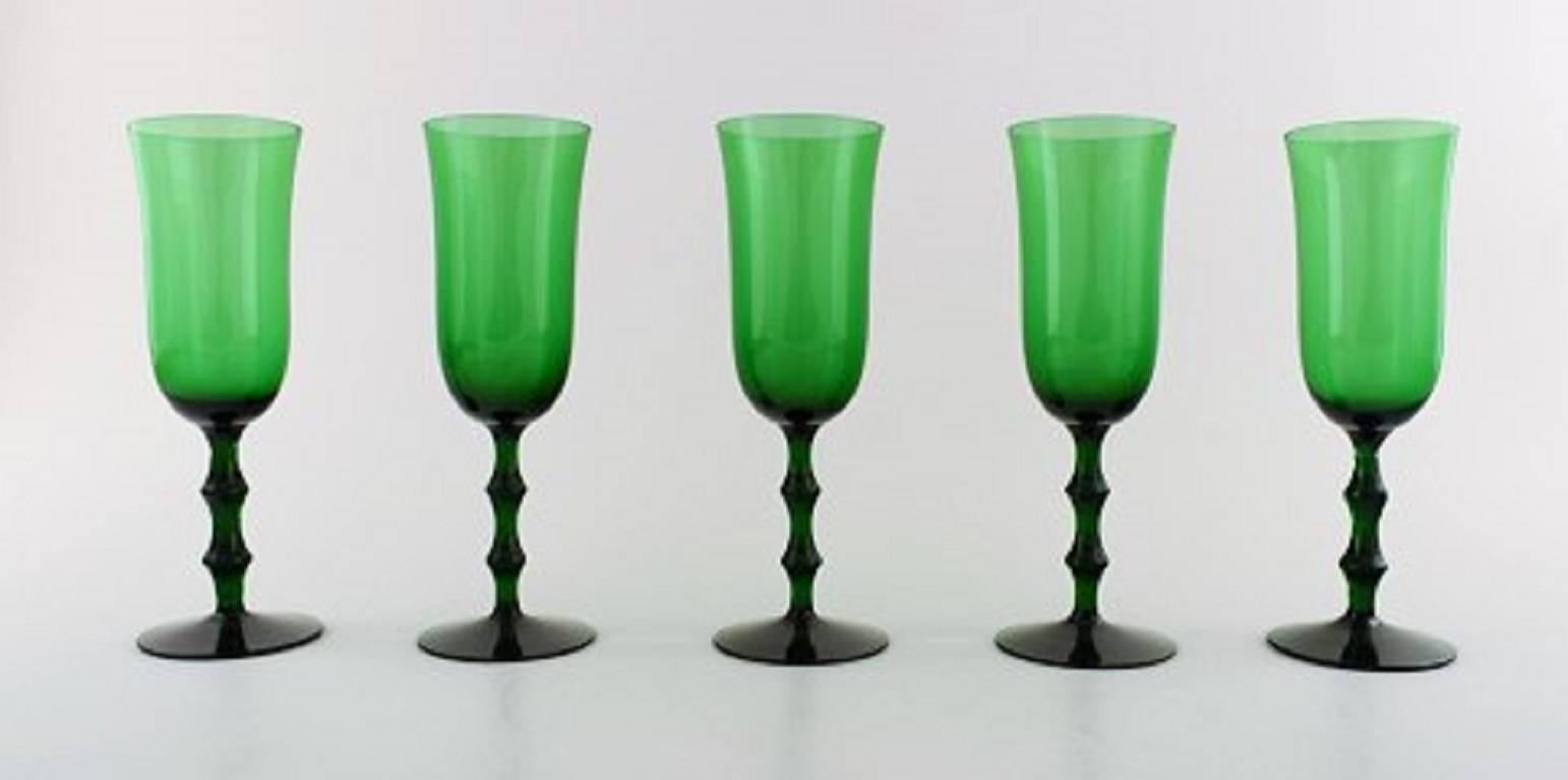 Simon Gate Orrefors, A set of nine green champagne art glasses. 
Designer: Simon Gate
Series: Salut
Producer: Orrefors
Country: Sweden
Designed: 1923
Size: Height 19 cm, diameter 6 cm. 
Quantity: Nine.